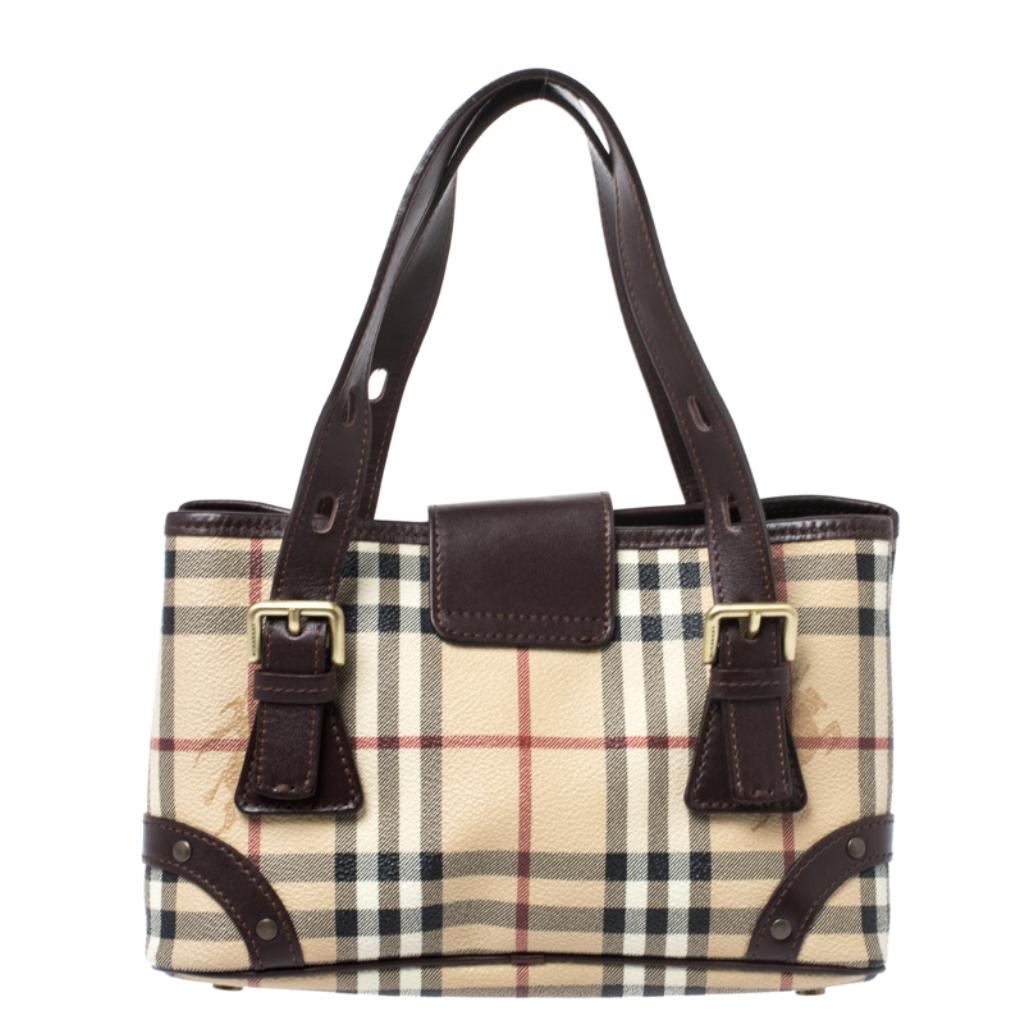 Elegant and classy, this Burberry bag would be a significant addition to your collection. Crafted from Haymarket check PVC it comes with a spacious fabric interior that will hold all your daily essentials. It features dual top handles and a buckle