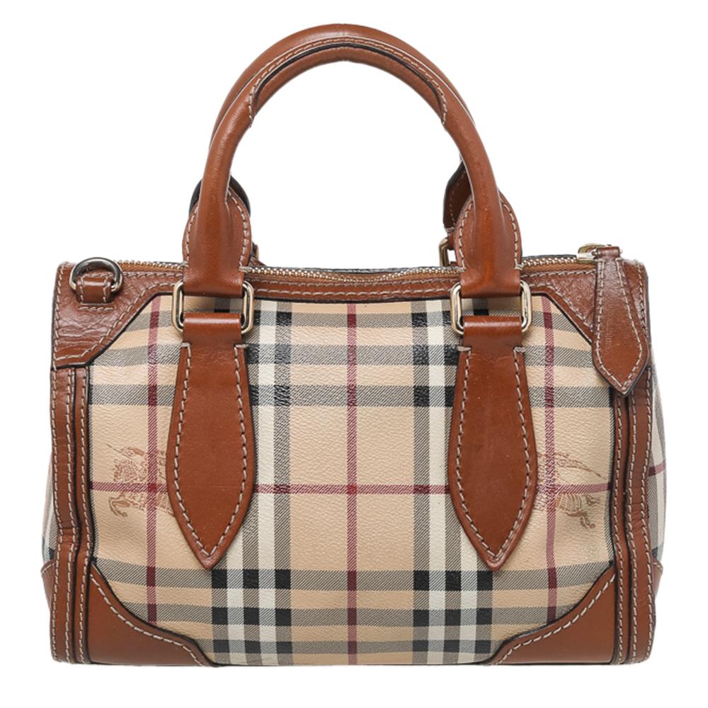 This Burberry satchel is a symbol of style and reliability. This bag is crafted from Haymarket canvas and leather. It is equipped with a spacious canvas interior, two handles, a shoulder strap, and gold-tone hardware.