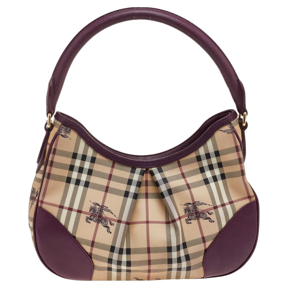 This Haymarket Check 'Hernville' Hobo by Burberry will be a stunning and timeless piece in your wardrobe. The pleated style exterior is made from check-printed canvas and with leather trim and piping. It's finished with a single handle and gold-tone