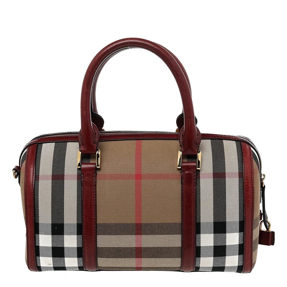 The signature House Check canvas with burgundy leather makes this Burberry Bowler bag an instant classic. Ideal for your everyday essentials, this bag also features gold-tone hardware that complements the overall design.

Includes: Strap