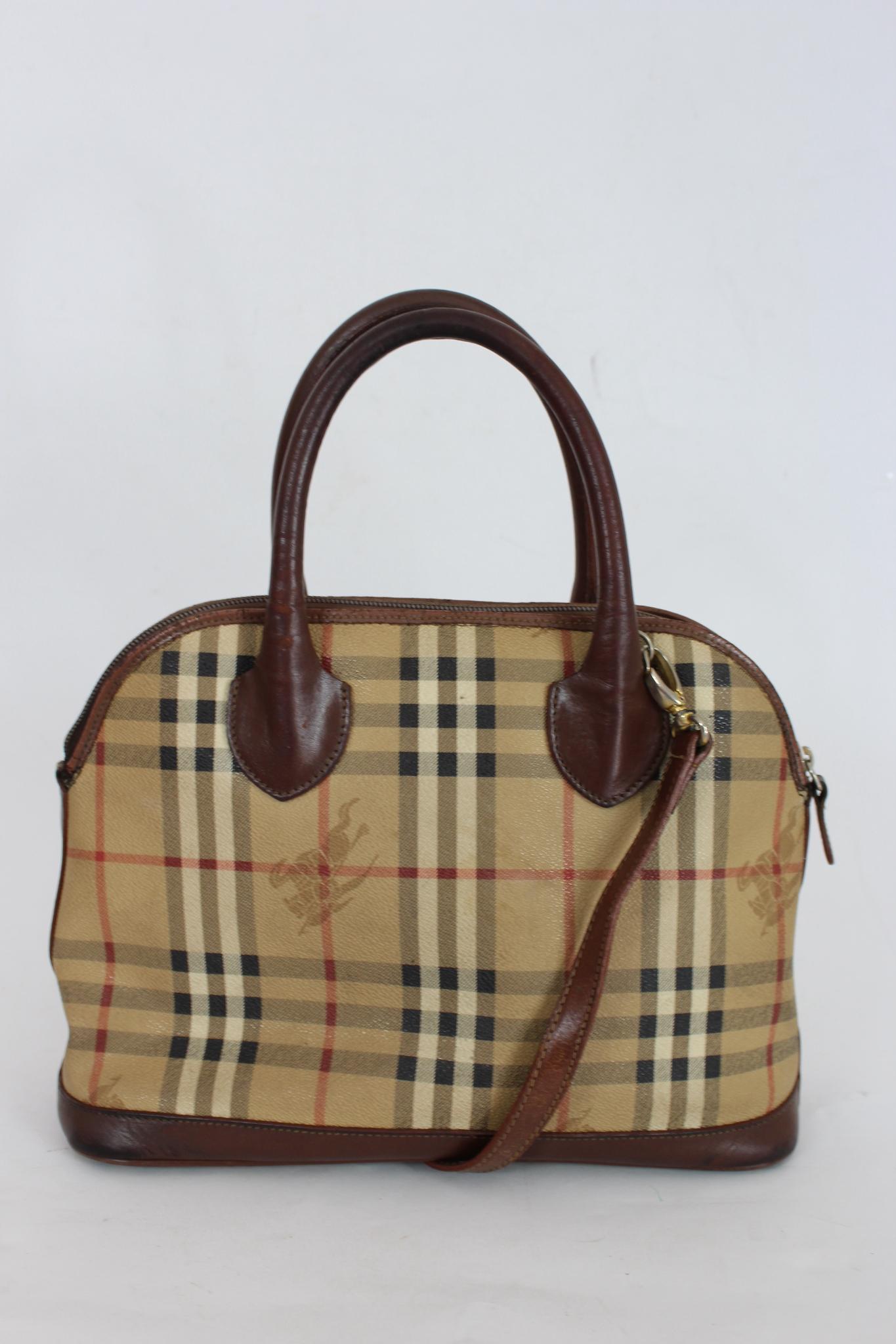 Burberry Vintage bag from the 90s. Classic beige canvas texture, with brown leather inserts. Large and comfortable brown leather handles. A long shoulder strap allows you to carry the bag over the shoulder. The internal space is very large, and