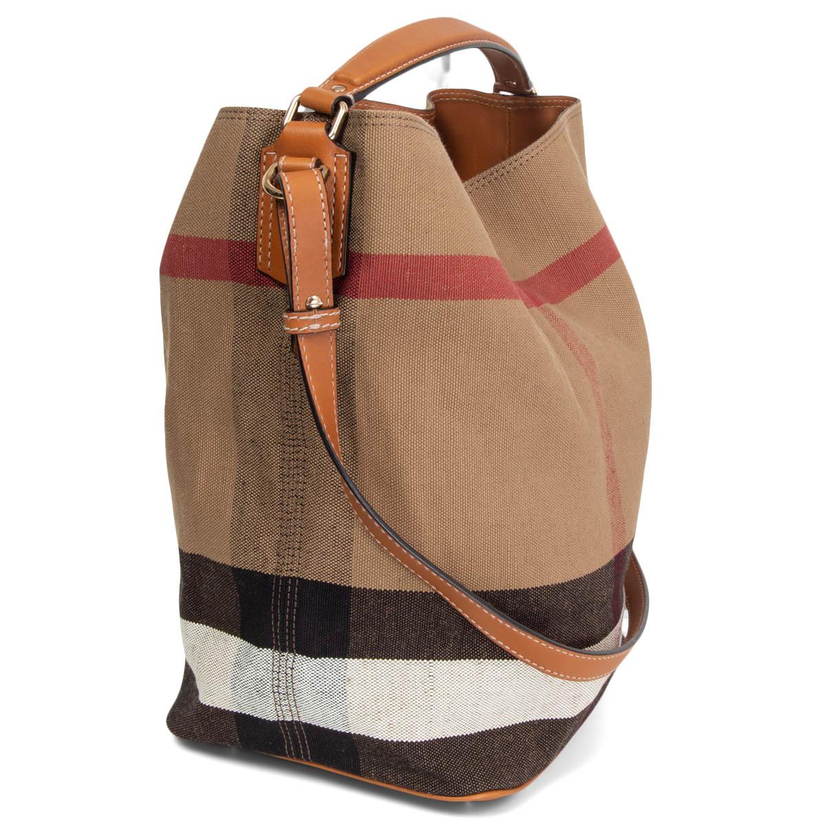 100% authentic Burberry Medium Ashby Bag in camel, red, white and black canvas and cognac brow leather trimming. Comes with a detachable and adjustable shoulder strap and top-handle. Closes with a dog-hook on top and is unlined. Has a detachable