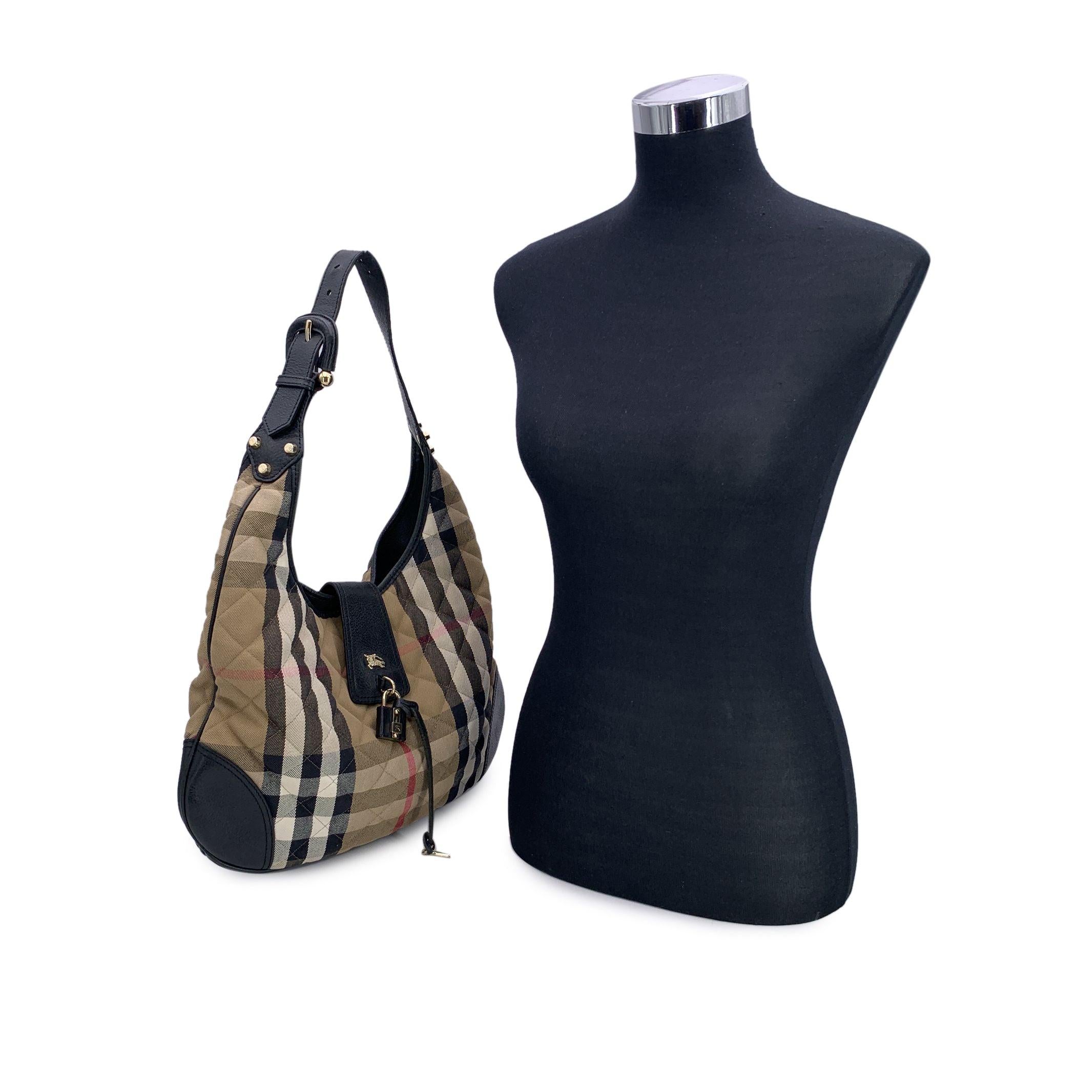 This beautiful Bag will come with a Certificate of Authenticity. The certificate will be provided at no further cost Introducing the Burberry beige quilted nylon Brook hobo bag, an iconic piece that blends functionality with the elegance of