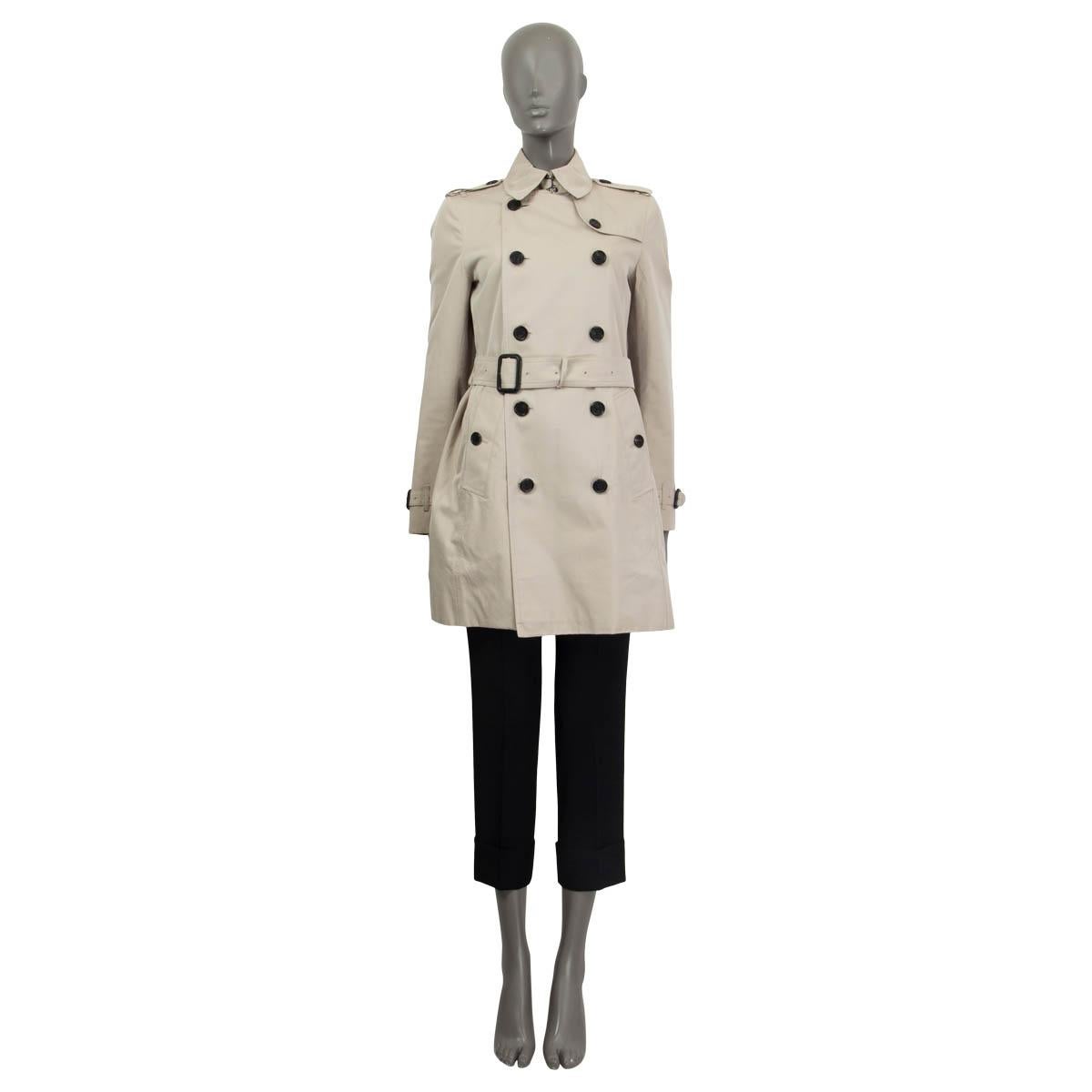 100% authentic Burberry belted double breasted trench coat in light sand cotton (100%) with shoulders and cuffs epaulettes and a detachable belt. Features two buttoned pockets on the front. Closes with one hook and one button at the neck and four