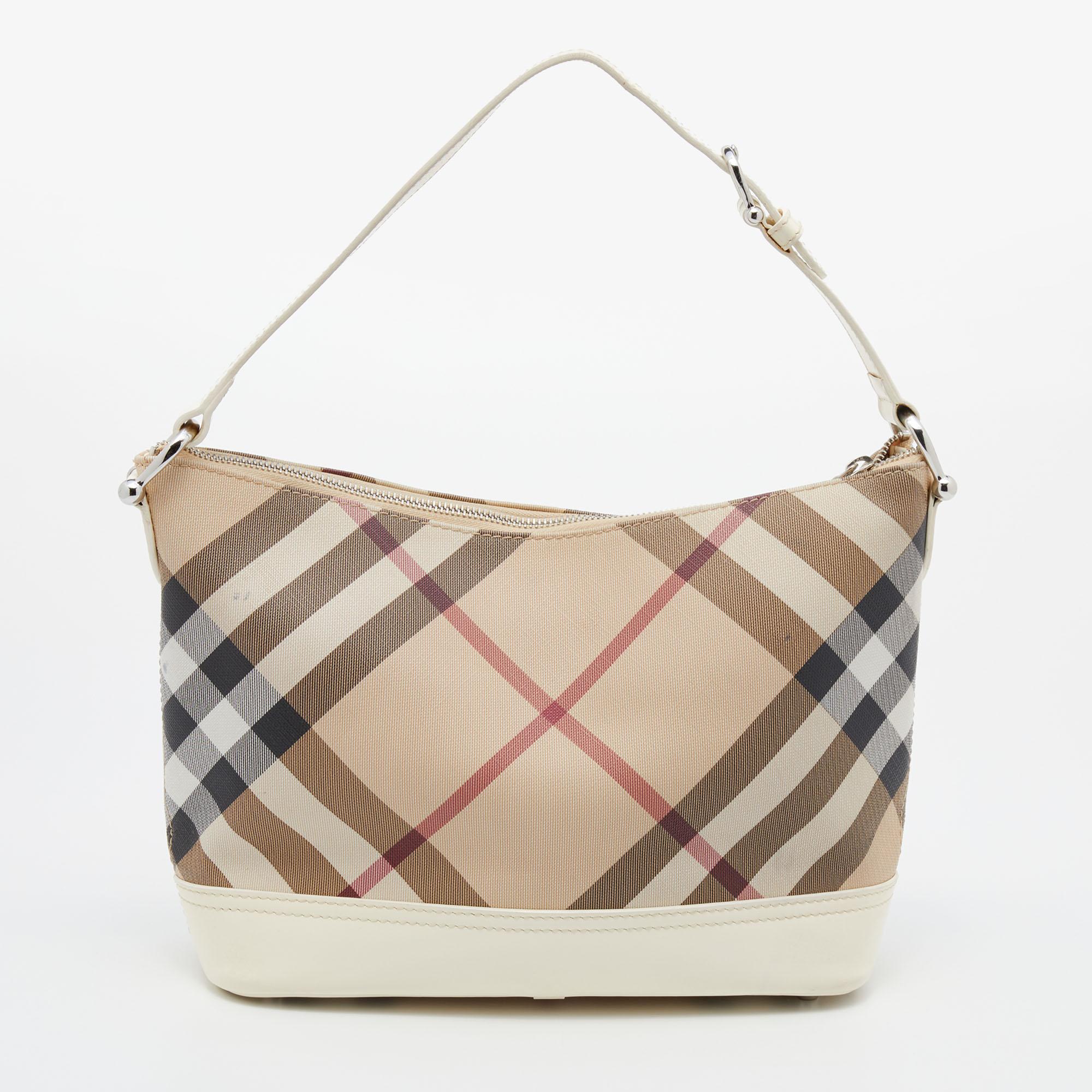 The simple silhouette and the use of Nova Check PVC and leather for the exterior bring out the appeal of this Burberry bag. It features a flat handle, silver-tone hardware, and a fabric-lined interior.

