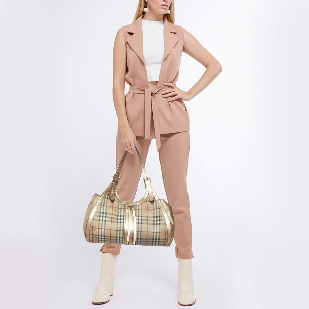 This hobo from Burberry is crafted from PVC in classic Haymarket check and completed with leather trims. The fabric-lined interior will hold your daily essentials and the hobo is complete with a single handle. Simple in design, it is perfect for