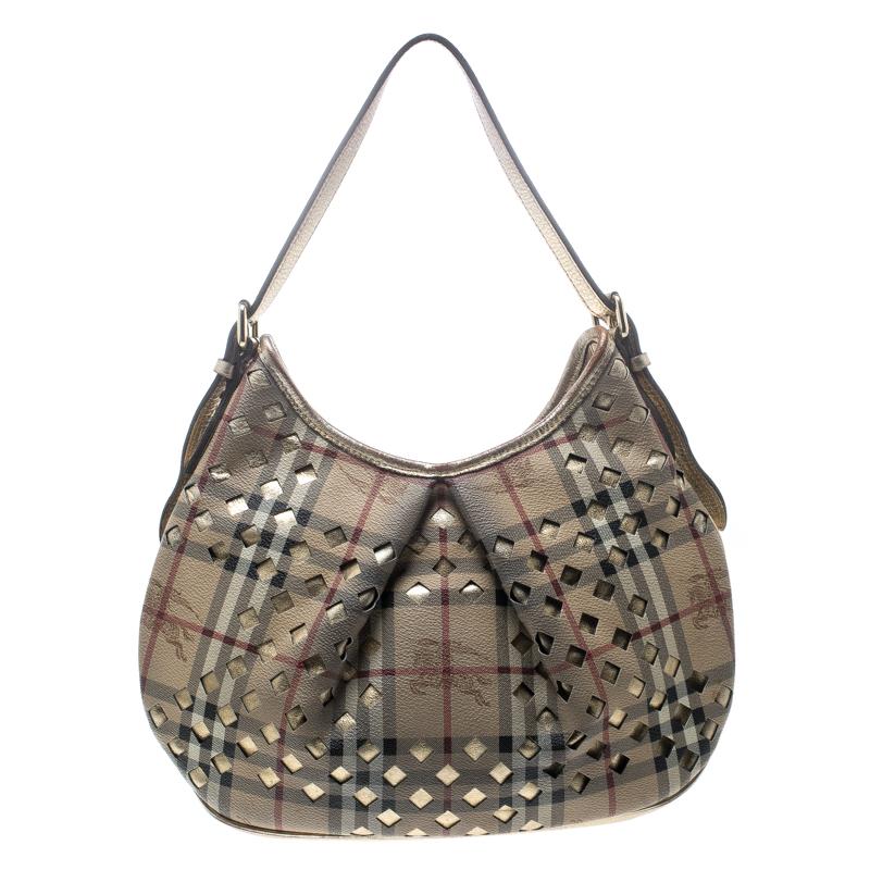 This hobo from Burberry is crafted from Haymarket check PVC and gold leather trims. It has cutouts all over, a shoulder handle and a drawstring closure that opens to a fabric-lined interior. Simple in design, the bag is perfect for everyday use.

