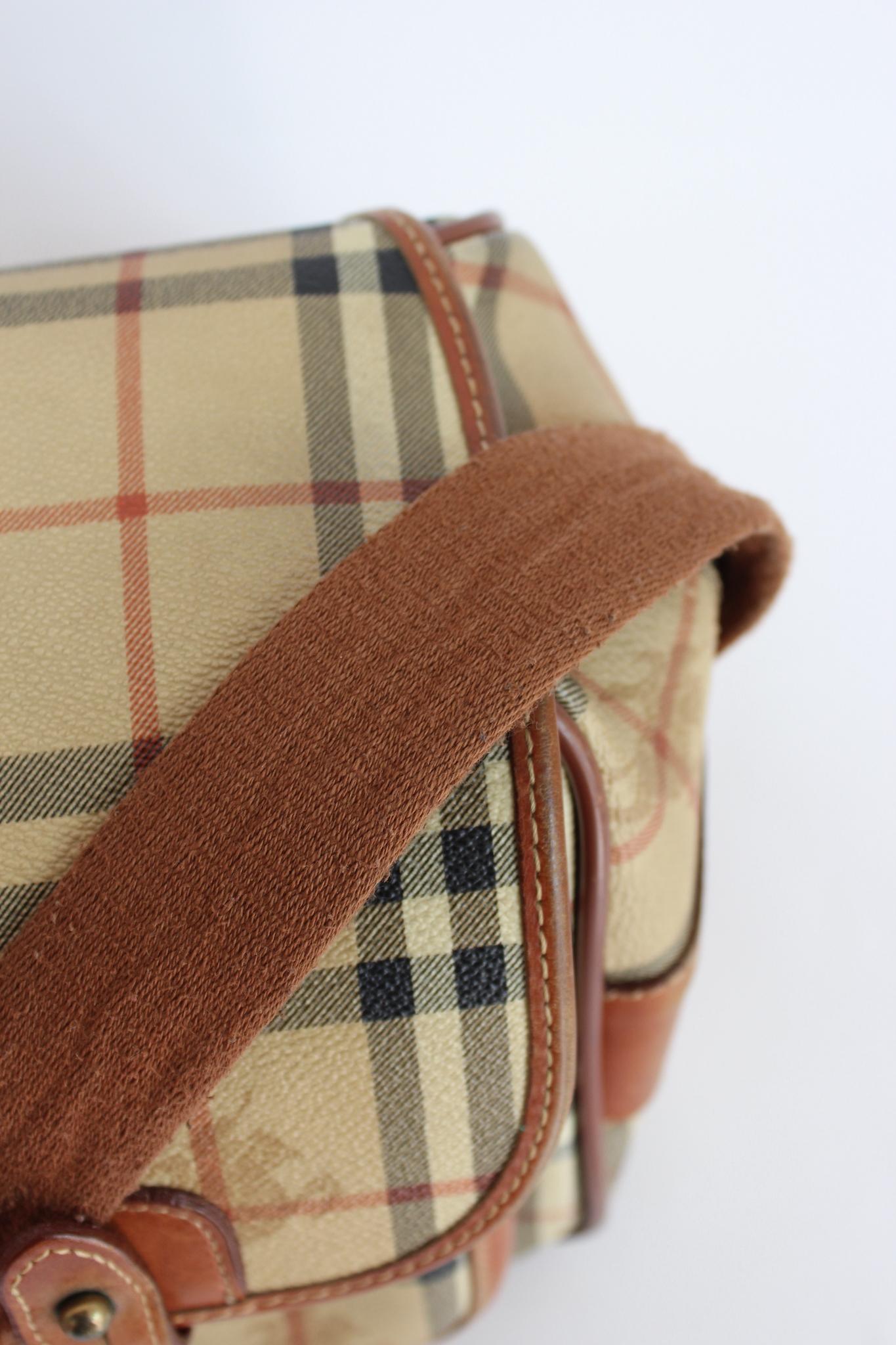 Burberry vintage 80s check trunk bag. Bag with adjustable shoulder strap, external pockets, buckle and zip closure. Canvas and leather fabric with typical Burberry pattern. Made in Italy. The bag is in perfect external and internal conditions, the