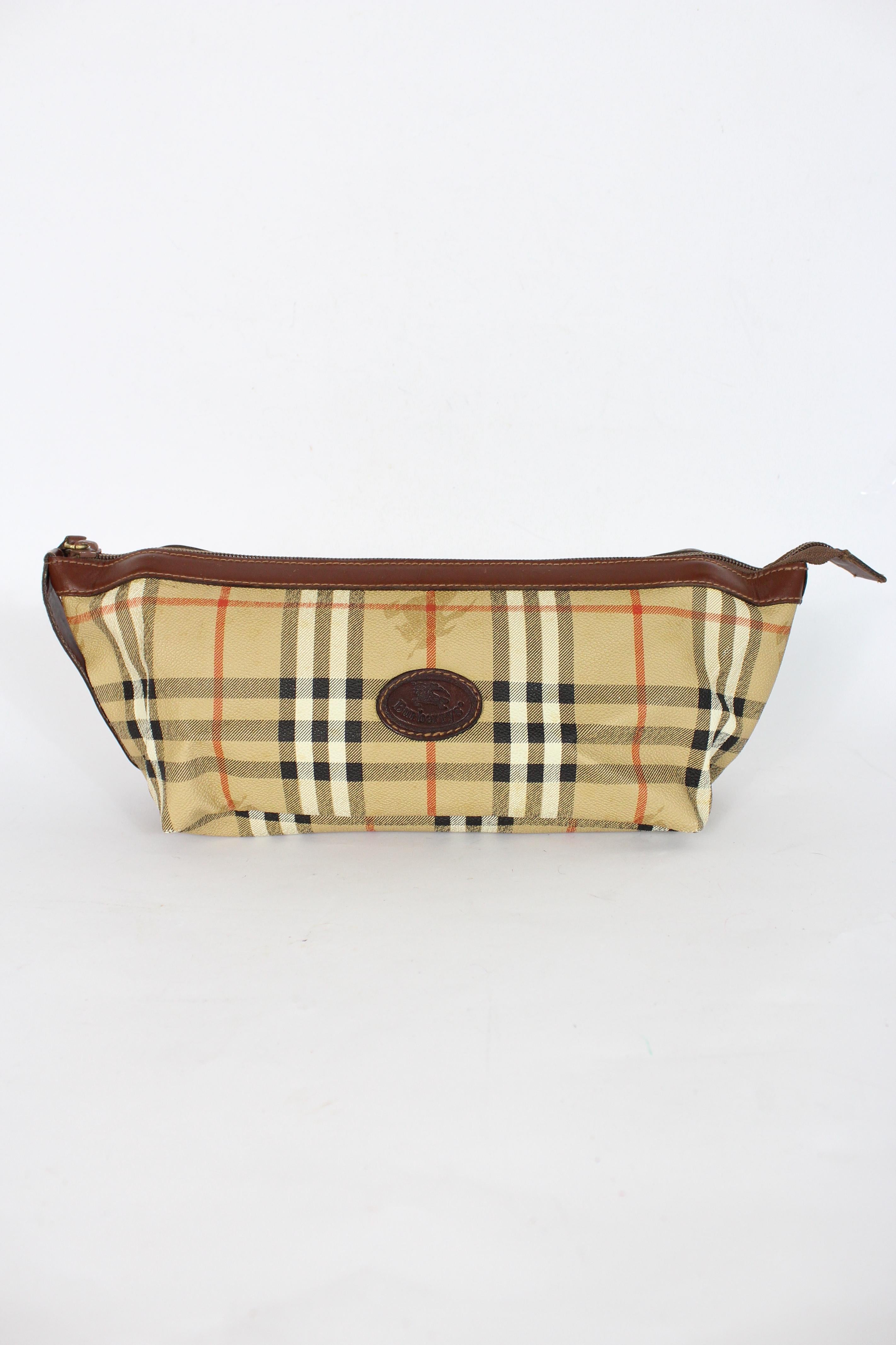 Burberry 80s vintage travel clutch bag. Bag for objects, beige color, tartan pattern. Zip closure, canvas and leather fabric. Made in Italy.

Condition: Excellent

Item used few times, it remains in its excellent condition. There are no visible