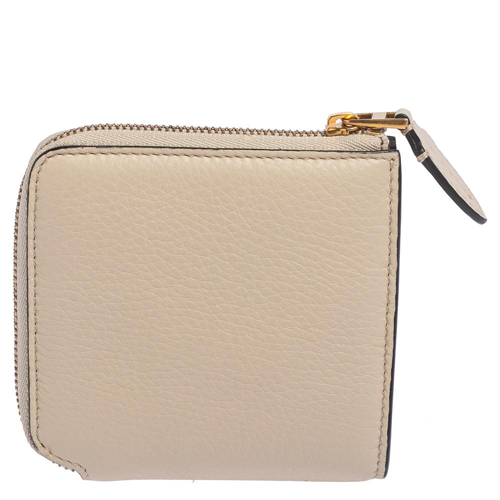 This wallet from Burberry brings along a touch of luxury and immense style. It comes crafted from beige leather and designed with half zip fastening. It is equipped with a leather-lined compartment so you can neatly carry your cards and