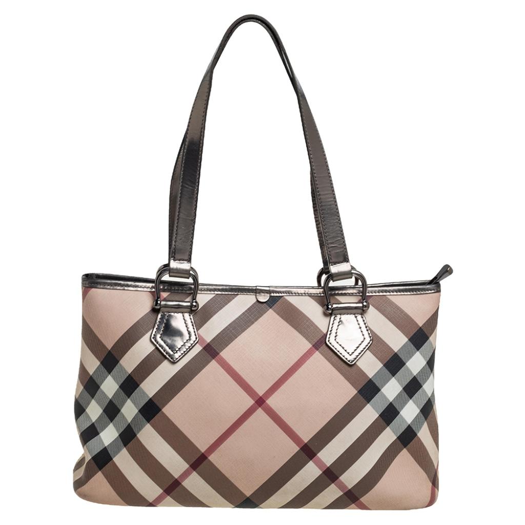Crafted in Nova Check PVC and leather, this tote is sure to make an amazing style statement. The interiors are lined with canvas to give it a mix of style and durability. Add a touch of minimized elegance when you style this Burberry handbag with