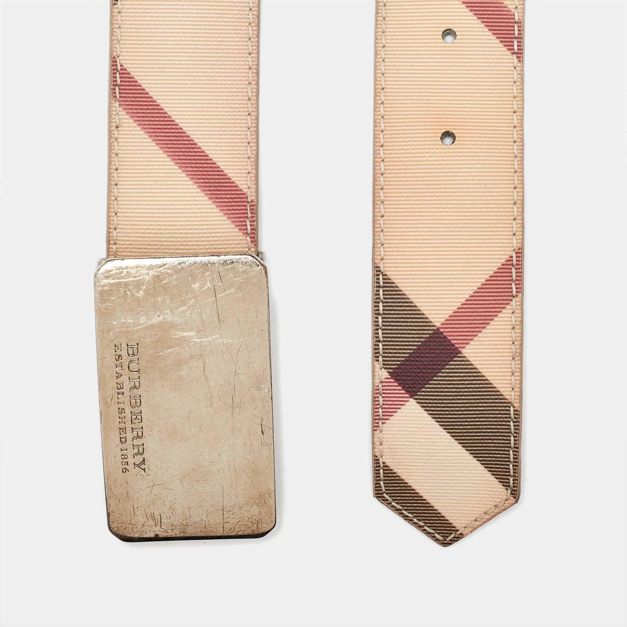 Gli accessori possono elevare senza sforzo un outfit e quale migliore creazione di una cintura per farlo? Abbiamo qui una cintura Burberry realizzata in tela rivestita Novacheck. È stato abbellito in una tonalità beige e presenta una targhetta con