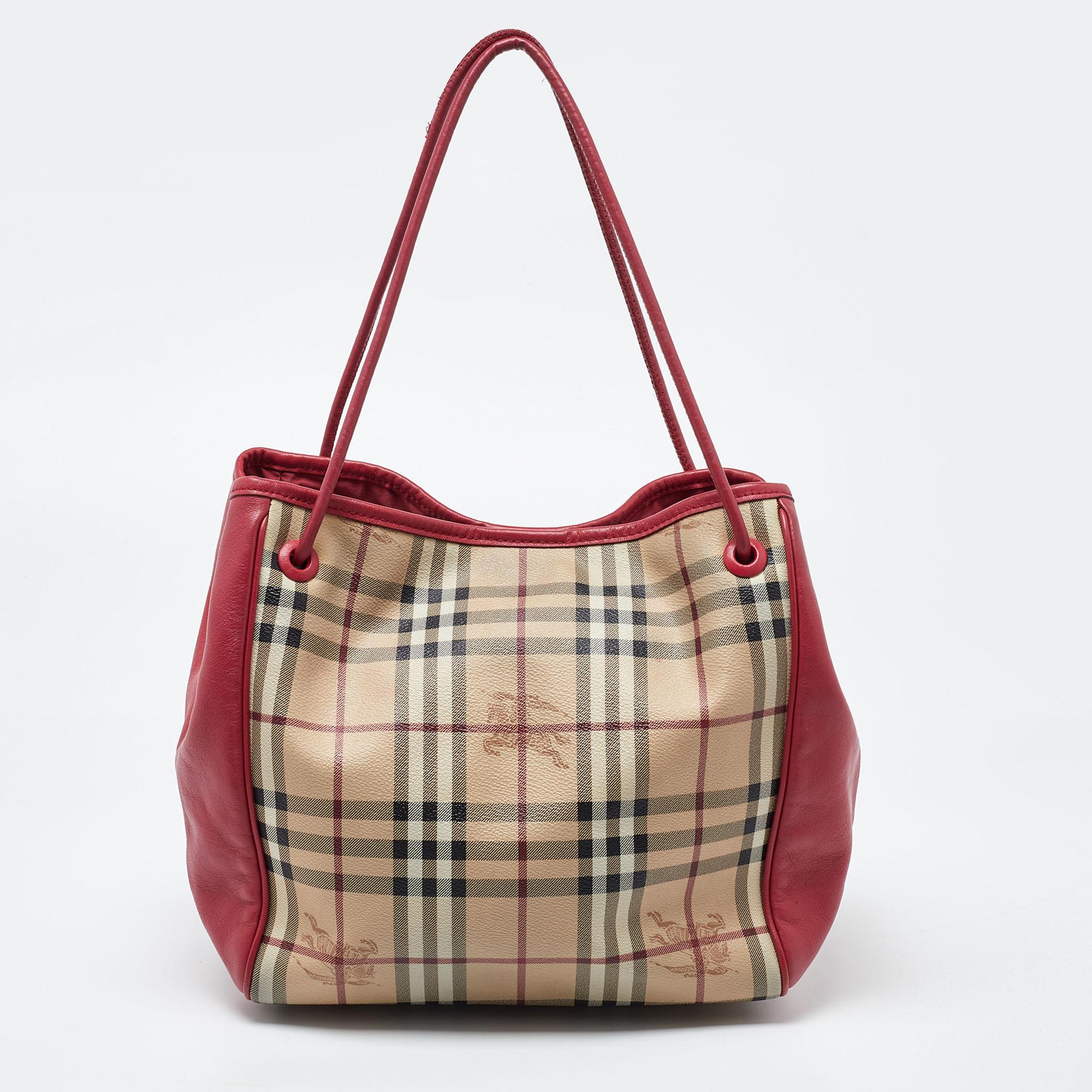 The Canterbury tote from Burberry will suffice your handbag needs with complete elegance. This tote is designed using beige-pink Haymarket Check coated canvas, leather, and gold-toned hardware. It is supported by dual handles and comes with a