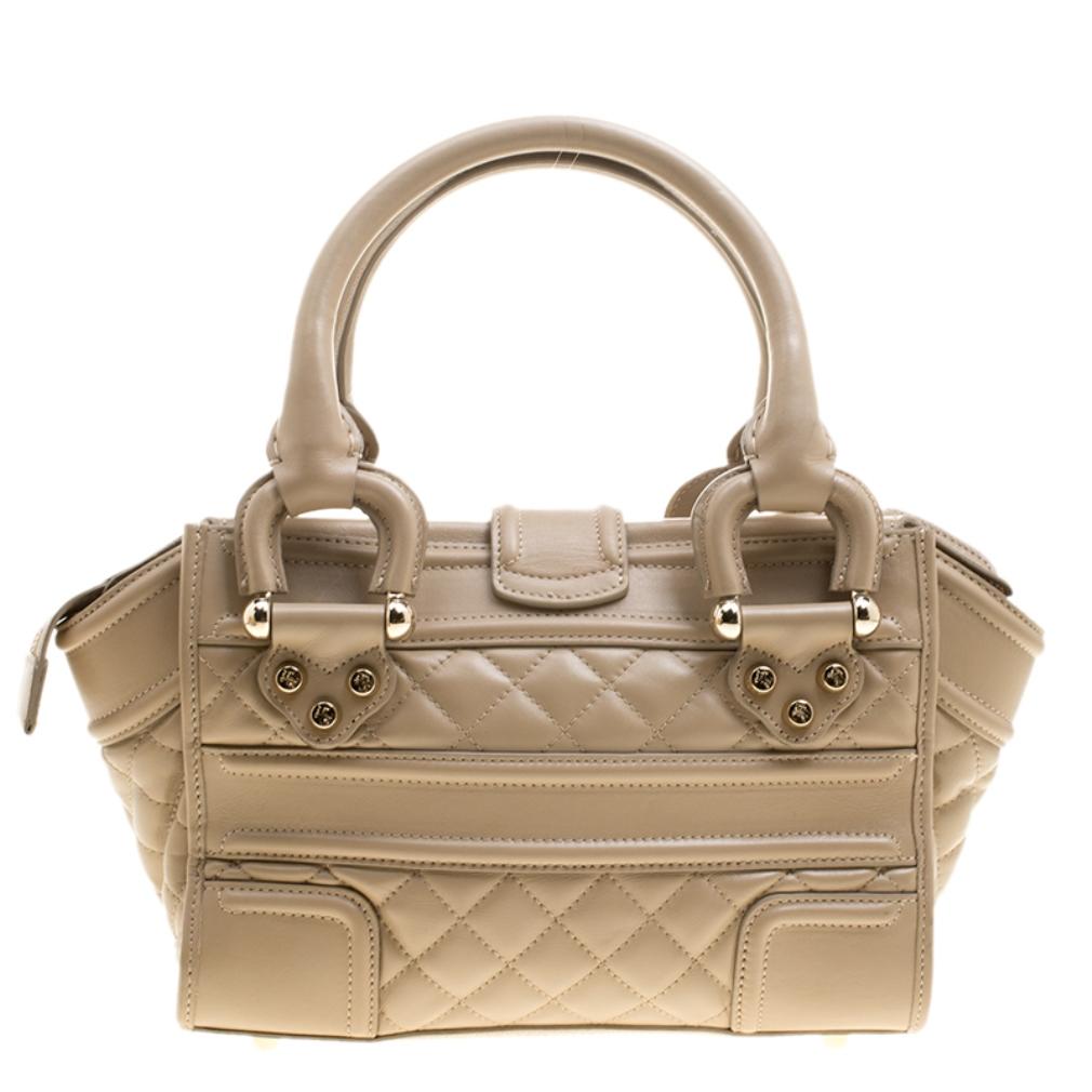 This Manor satchel from Burberry is updated with a soft beige hue. It features a quintessential quilted design adorned with leather trims. Covetable and contemporary, the leather bag is further detailed with embossed gold-tone studs and a