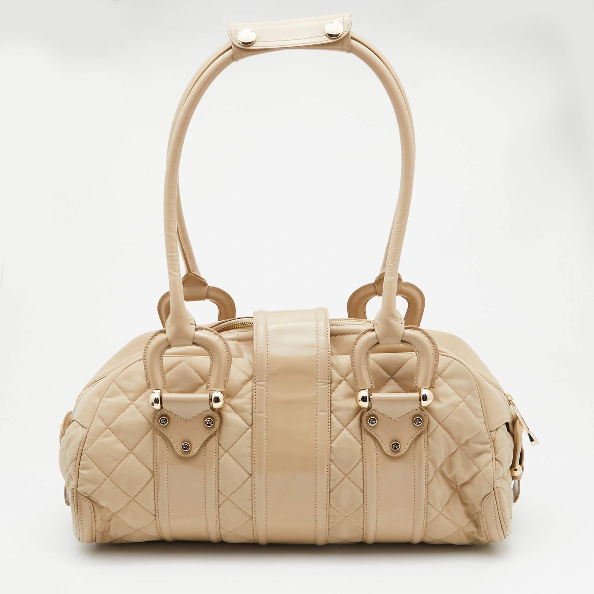Made from quilted nylon and leather, this one will make a spectacular addition to any contemporary outfit. This practical and stylish satchel in a beautiful beige colour can be paired with multiple attires. The interior is lined with fabric and it
