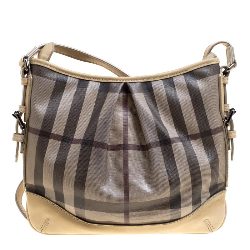 Complete a stylish look with this beautiful Burberry bag. It has been wonderfully crafted from Smoke Check PVC and designed with leather trims and a zipper leading to a spacious canvas interior. This crossbody bag is completed with a leather