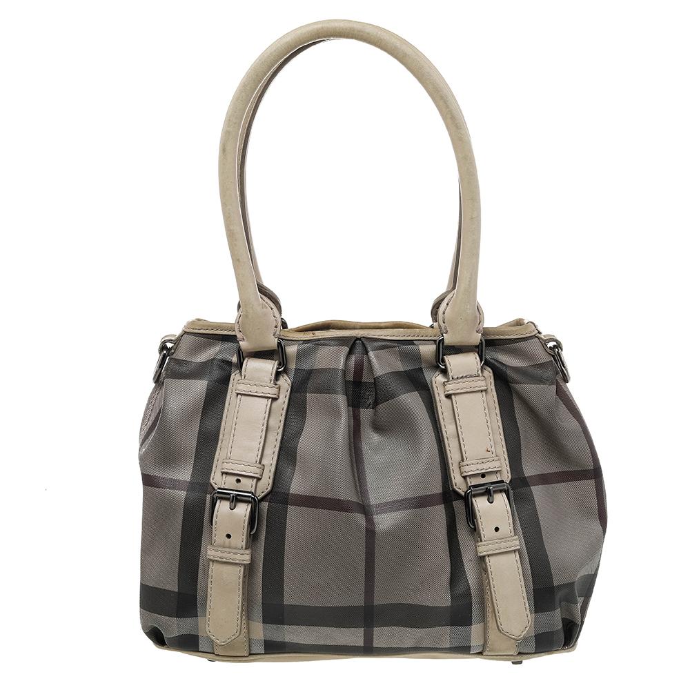 Spacious and captivating, this Northfield tote is from Burberry. It has been crafted from Smoke check PVC and enhanced with leather. It is equipped with two rolled handles, a detachable shoulder strap, and a well-sized fabric interior. Lastly, the