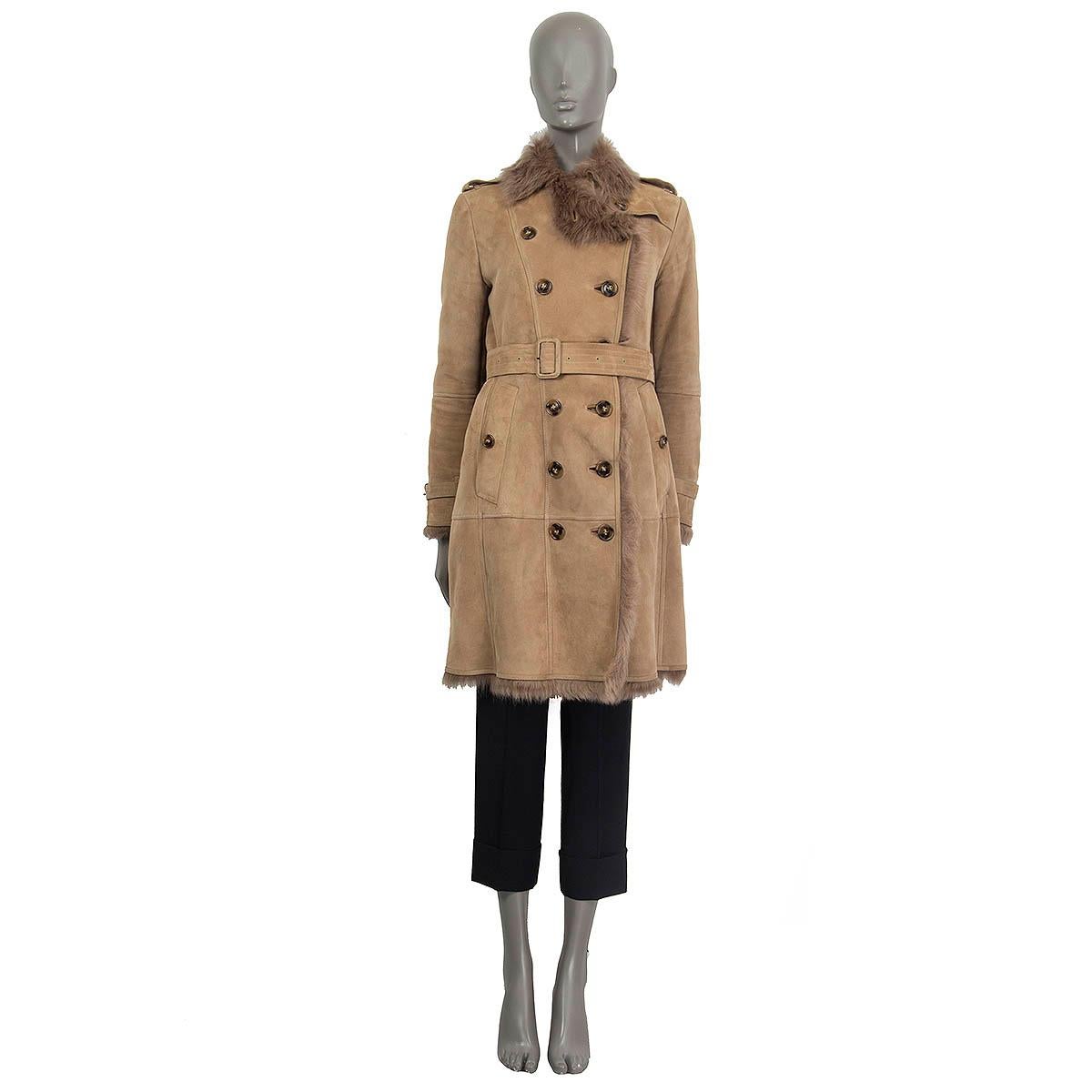 100% authentic Burberry London double breasted trench coat in beige lamb shearling (100%). Features a detachable belt, epaulettes at the shoulders and the cuffs and two buttoned pockets on the front. Opens with eight buttons on the front. Pockets