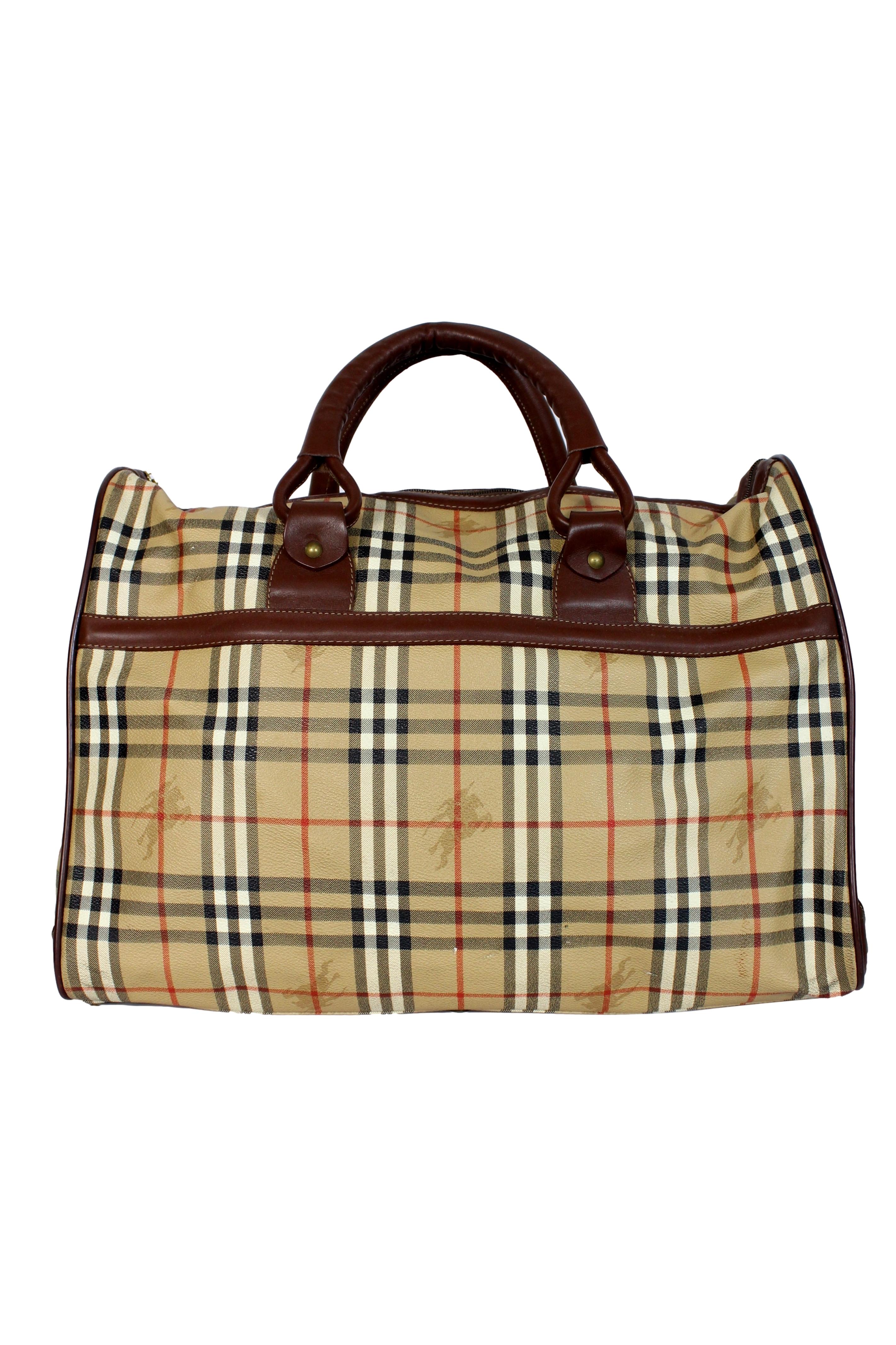 Burberry vintage beige tartan travel Bag 1980s. Semi-rigid luggage bag, beige and brown with gold-colored details. Fabric in canvas and leather. Large compartment on the front, zip closure. Made in Italy.

Condition: Excellent

Item used few times,