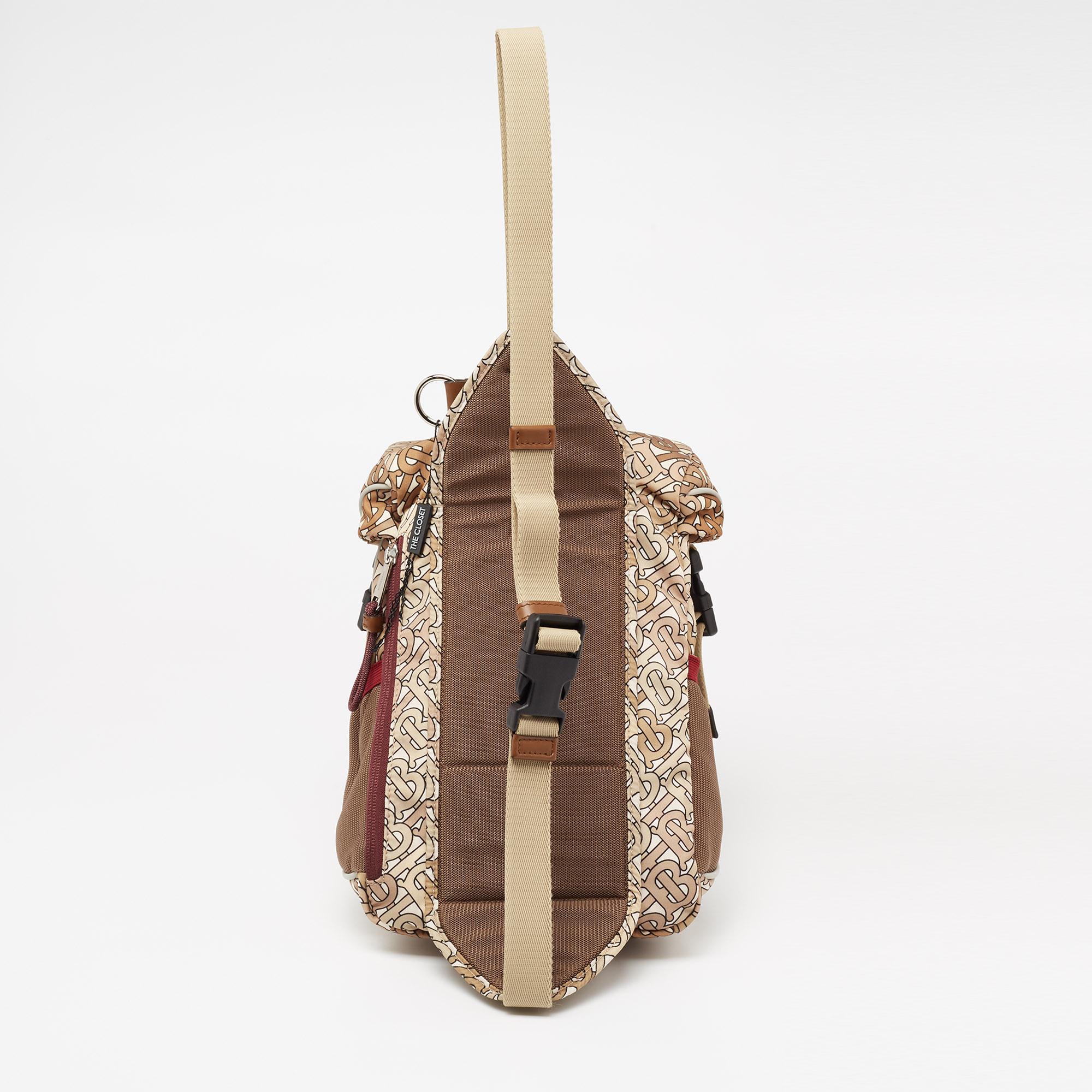 Lend your outfit the signature aesthetics of Burberry with this Leo backpack. Made from nylon, it is adorned with the signature TB monogram and features a front zipper pocket, a single buckle strap, and silver-tone hardware. The interior of this