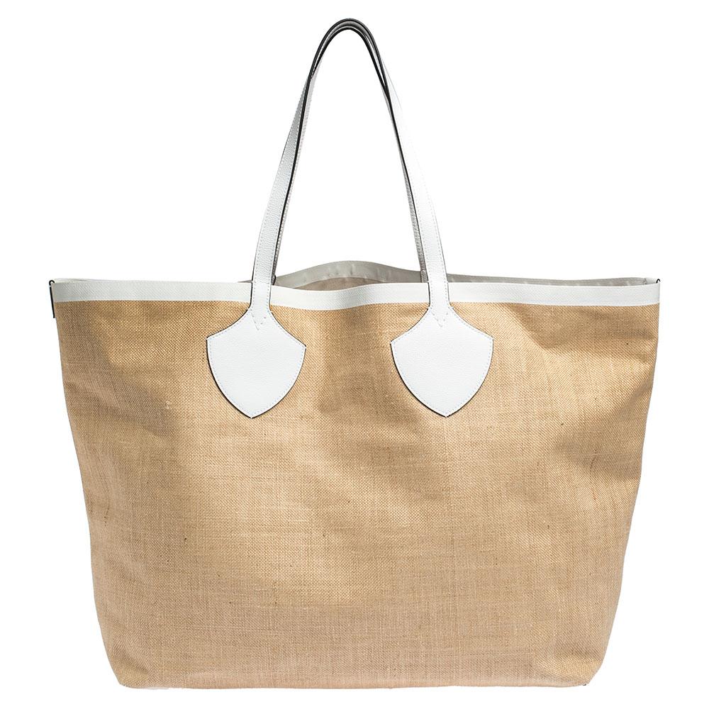 This All Giant tote by Burberry has a structure that simply spells ease. Crafted from jute and leather trims, the bag is elegantly held by two leather handles. The tote comes with a canvas interior that has enough space to store your