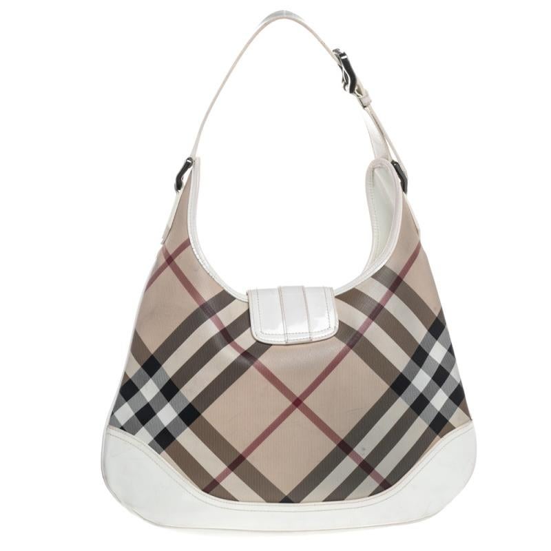 This Burberry ‘Brooke’ bag will not let your style down. It features a classic Nova Check exterior with patent vinyl panels, a single handle, and magnetic snap closure. The fabric-lined interior comes with one large zipper pocket.

