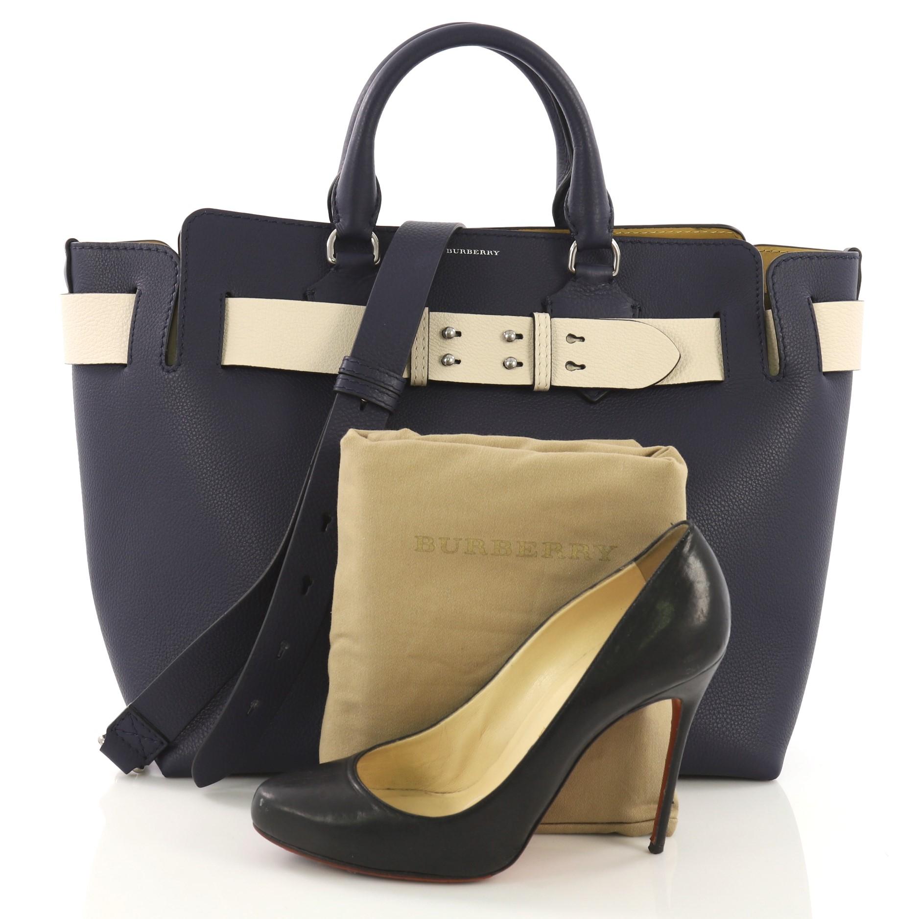 This Burberry Belt Tote Leather Medium, crafted in blue leather, features dual rolled leather handles, wide belt at the top, and silver-tone hardware. It opens to a yellow leather interior with slip pockets. **Note: Shoe photographed is used as a