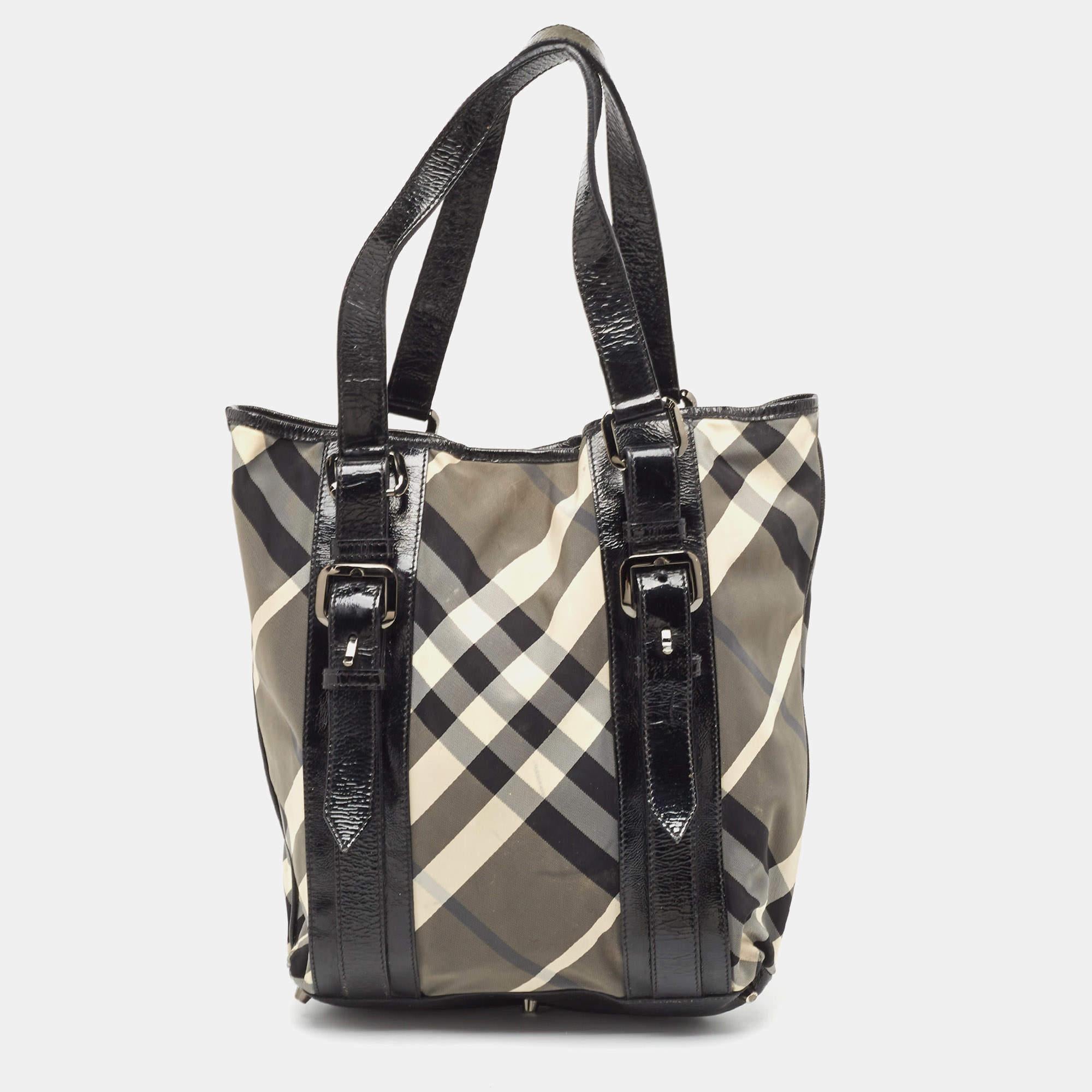 Complement a stylish look with this beautiful Burberry tote. It has a Beat Check nylon & patent leather exterior and a spacious nylon interior. This bag is completed with buckles and flat handles.

