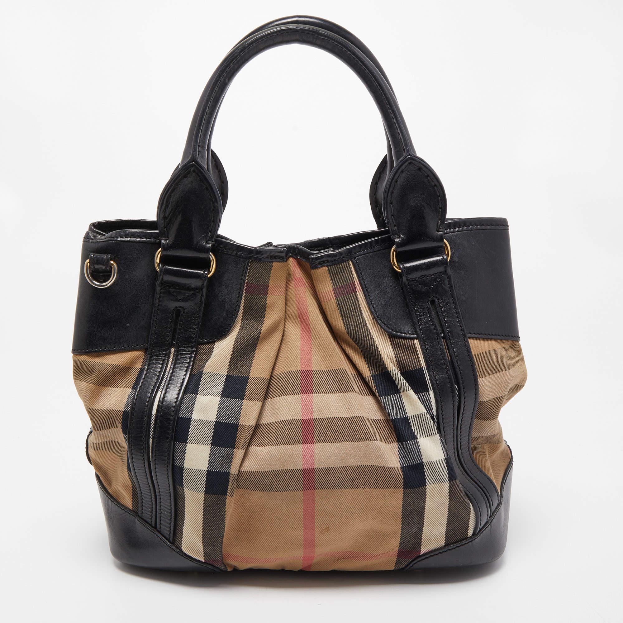 This Burberry tote promises to take you through the day with ease, whether you're at work or out and about in the city. From its design to its structure, the House Check canvas & leather bag promises charm and durability. It has top handles, an