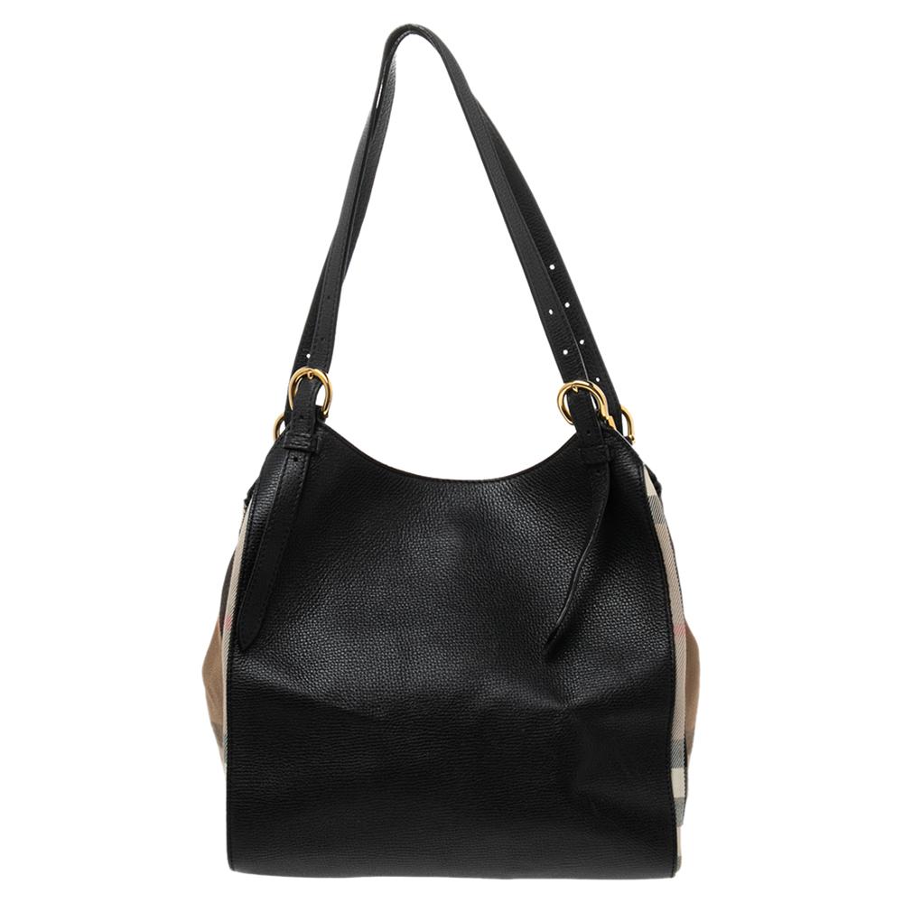 Flaunting the signature House Check coated canvas and leather exterior, this Burberry Canterbury tote is all about perfection. It contains a dual handle drop, protective metal feet and is completed with gold-toned hardware. Simple in design, this