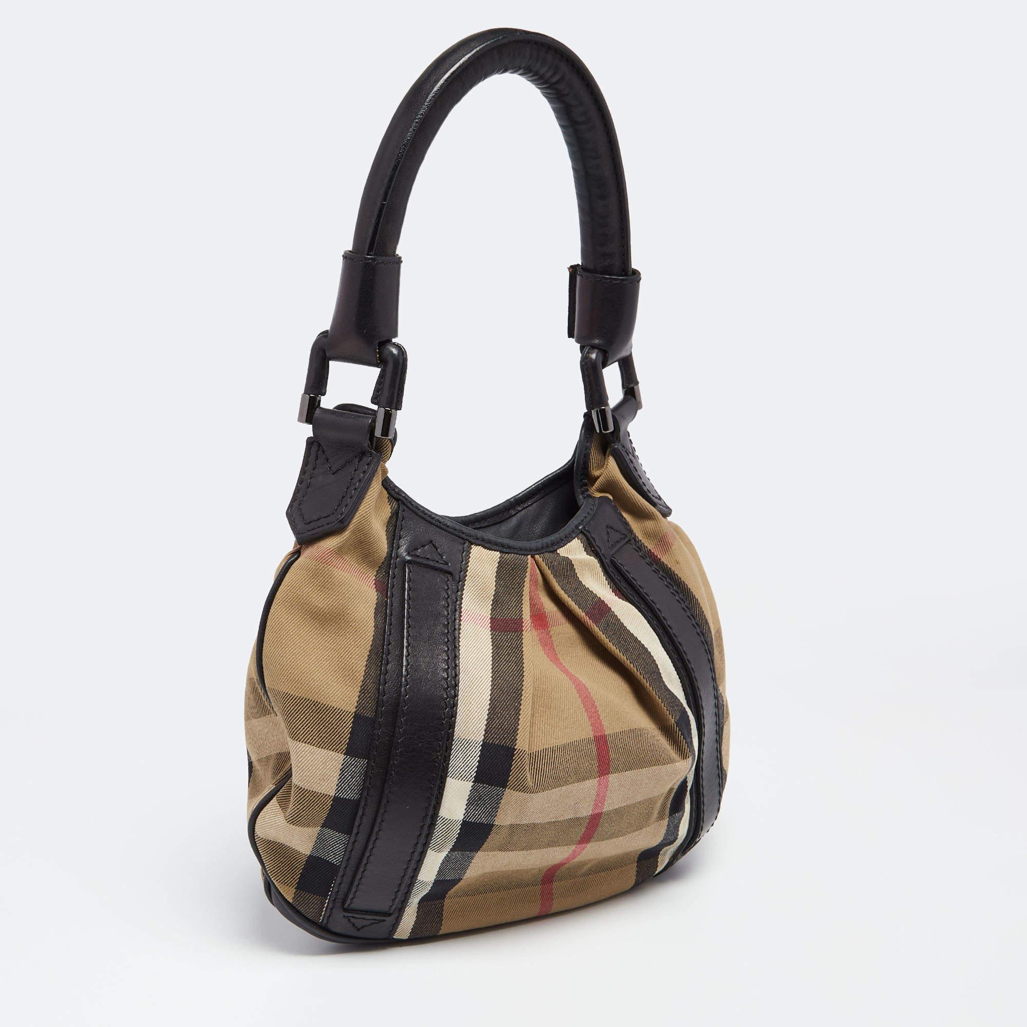 This Phoebe hobo from the House of Burberry is absolutely gorgeous! Made from black-beige House Check canvas and leather, this hobo is highlighted with black-tone hardware and a single handle. It accommodates a roomy canvas-lined interior. Carry