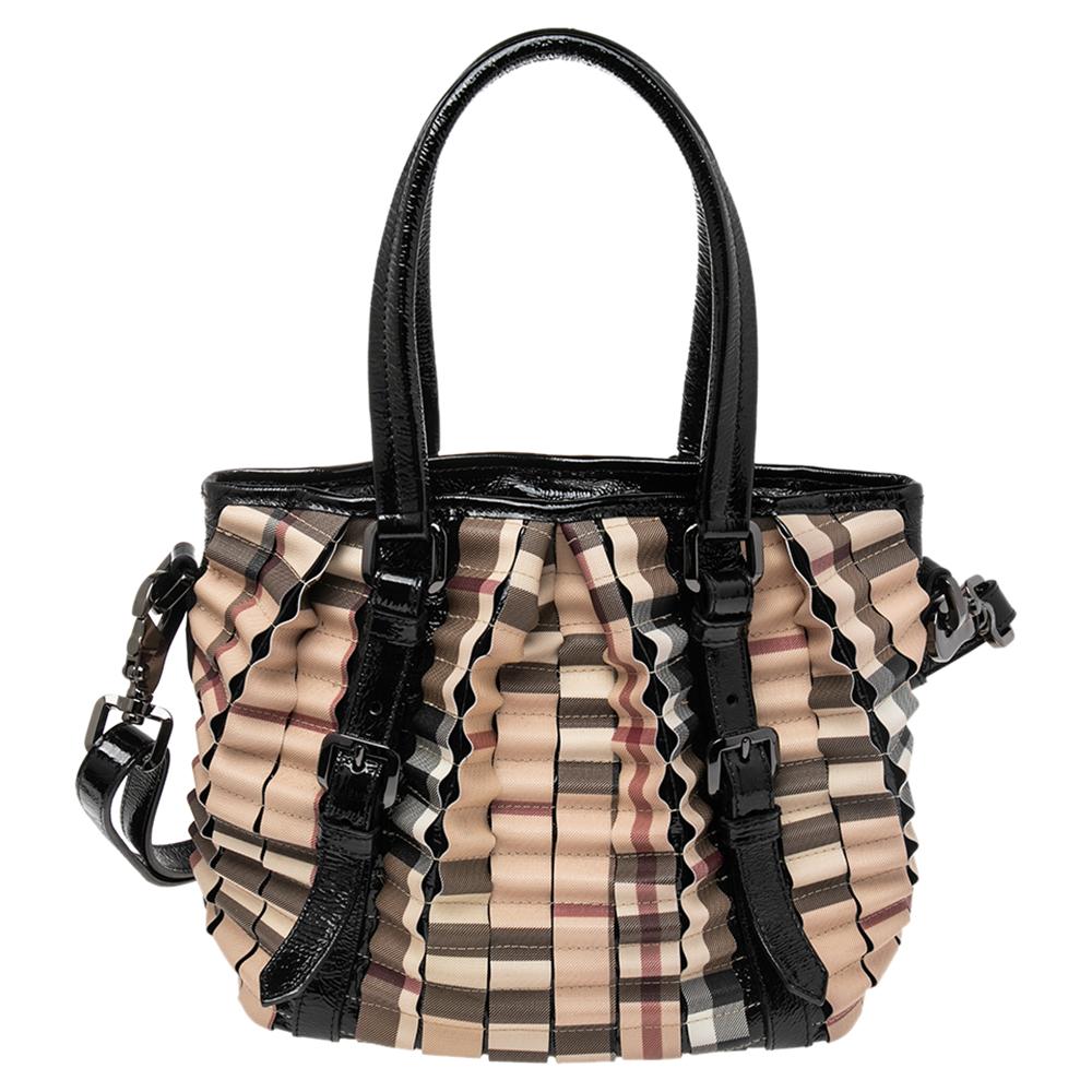 The tote from the house of Burberry features the iconic House Check PVC as pleats running all over the bag. Held by two patent leather handles and equipped with a spacious canvas interior, the bag is a great option to carry for work.

Includes: