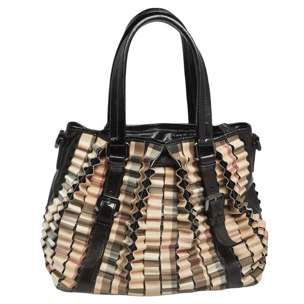 This Burberry Lowry is a harmonious fusion of excellent craftsmanship and timeless style! Meticulously made from House Check PVC and patent leather, the bag features a lovely ruffled exterior. The bag is equipped with protective metal feet at the
