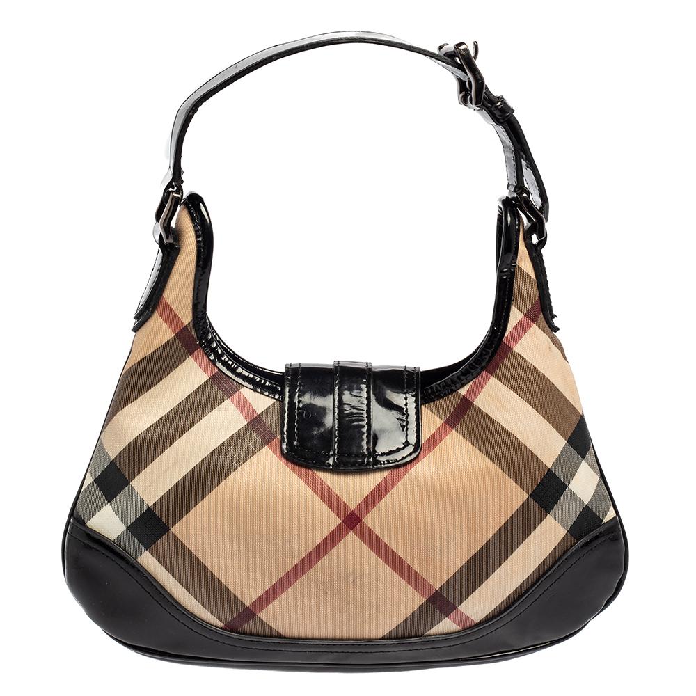 Step out in style with this version of the Brooke hobo from the British luxury fashion house of Burberry. Designed in classic Nova check PVC the bag features a single patent leather handle and a front flap closure. It has a roomy interior that