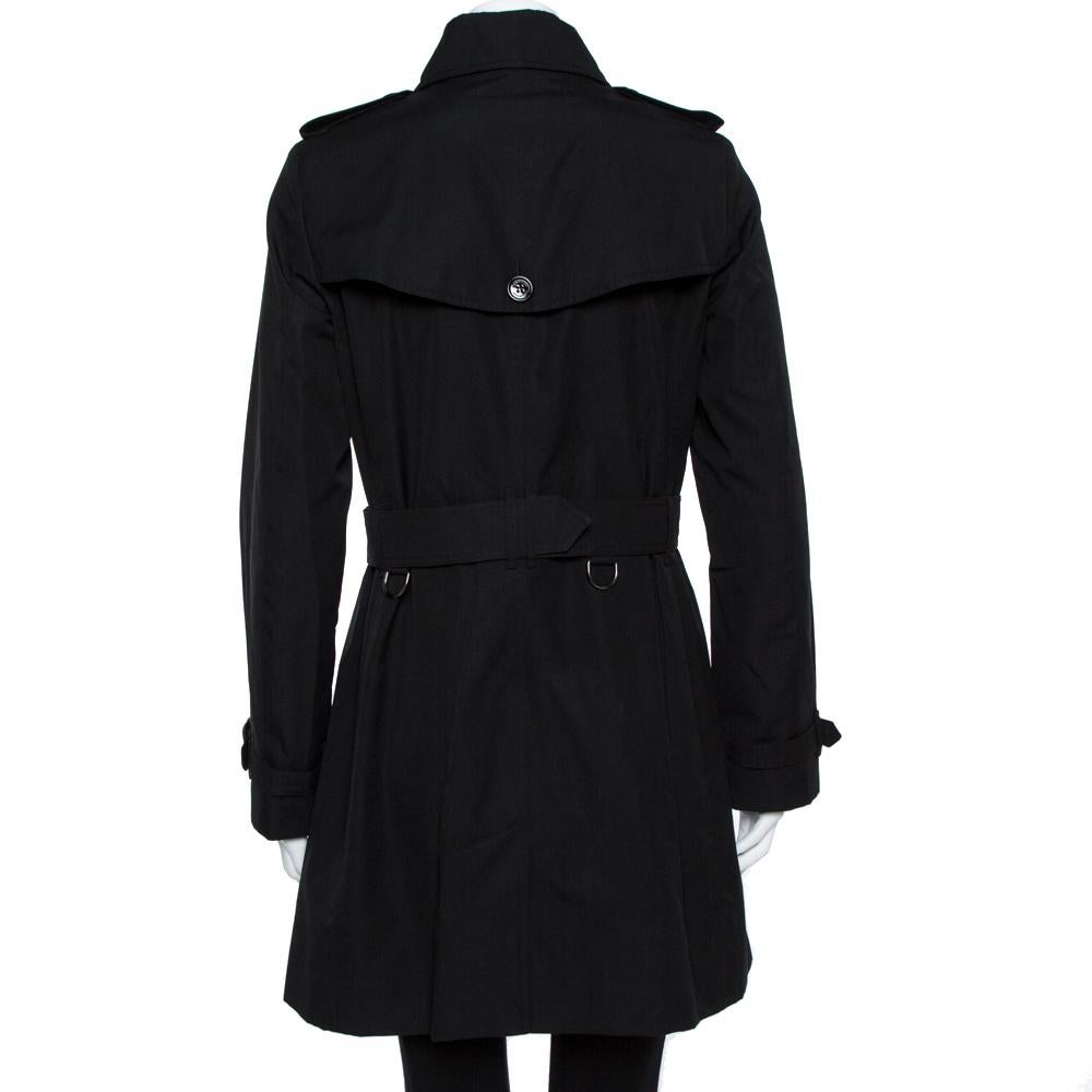 Burberry's coats are a dream addition to any woman's closet. This black creation was crafted from quality materials and it not only carries a well-tailored silhouette but also stylish details like the collar, the double-breasted style, and two
