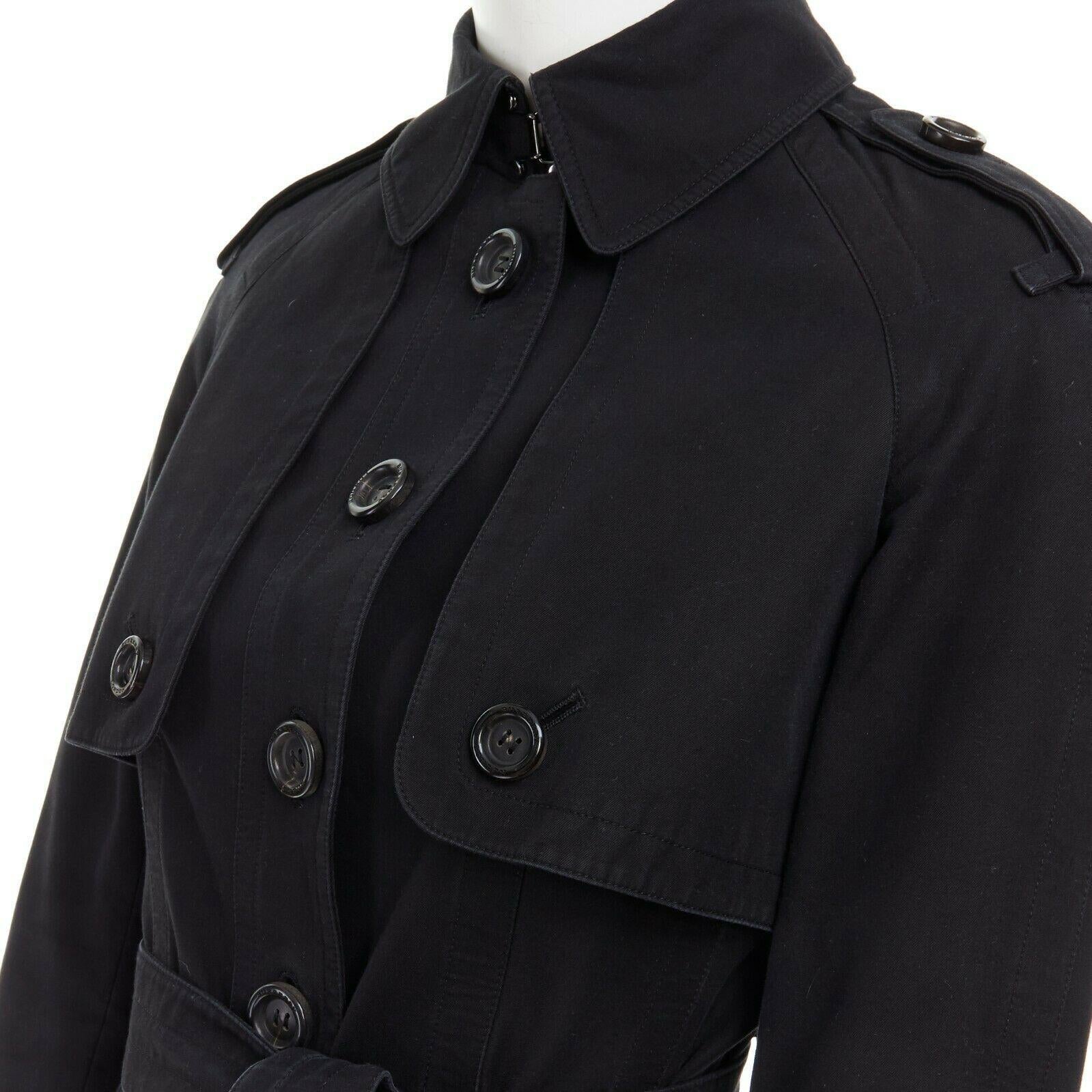 BURBERRY black cotton house check lined button front mid length trench coat S
BURBERRY
100% cotton. 
Black. 
Spread collar. 
Button front closure. 
Large resin button with Burberry London engraved. 
Shoulder epaulette. 
Button pockets. 
Long