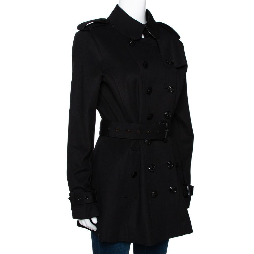Always feel in sync with classic fashion with this Burberry coat. This black piece will make a fashionable add-on over any outfit. It is tailored from durable materials and designed with a double breasted front. The belt adds the perfect finishing