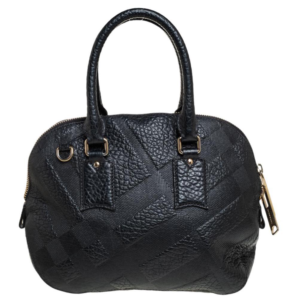 Expertly crafted and skillfully designed, this Burberry creation is a must-have in every woman's collection. It is made from embossed black leather and features two handles and a spacious fabric interior. Ideal for any day, this sophisticated bag