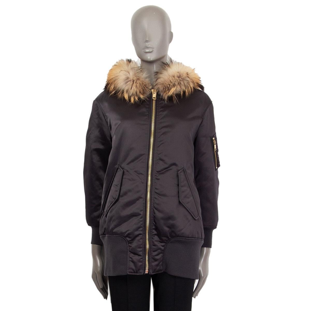 authentic Burberry bomber parka in charcoal polyamide (100%), hood fur trim in asiatic raccoon (100%), cuffs and hem in wool (86%) and polyamide (14%). Closes with a zipper on the front and has two flap pockets. Lined in acetate (70%) and cupro