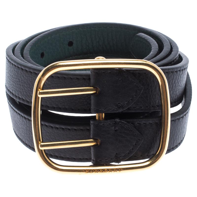This Burberry belt has two slender straps running parallel to create a unique silhouette. Rendered in leather, th belt is adorned in black and green shades and has a wide buckle in gold-tone at the centre. Add a touch subtle style to your outfits