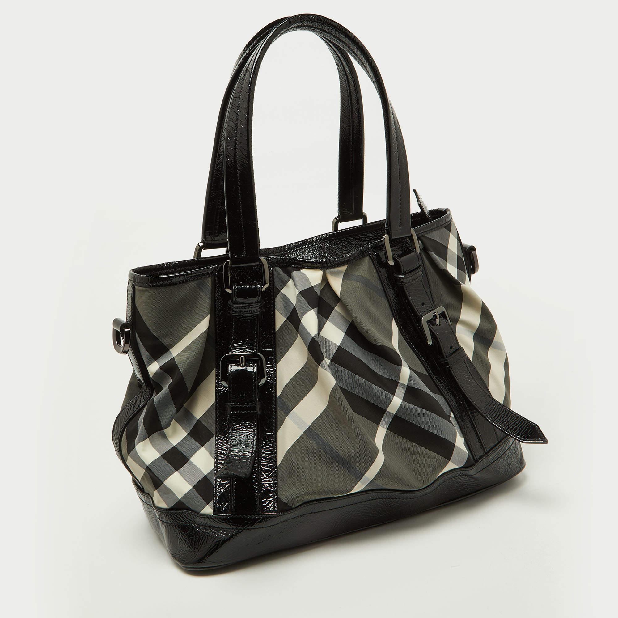 Simply gorgeous and built to endure through all your busy days, this Burberry tote is a worthy investment. It has been crafted from patent leather and nylon in their Beat check and equipped with two handles and a spacious interior. The bag is