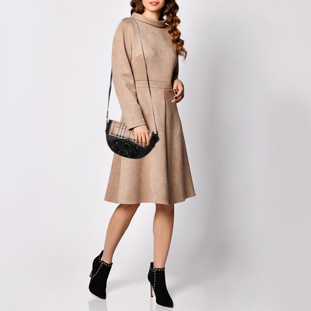 Diese Burberry Maydown Crossbody wurde in Italien aus feinem Leder und beschichtetem Canvas gefertigt. Das Äußere trägt das für die Marke charakteristische Haymarket-Karo sowie eine schlichte schwarze Oberfläche mit Schleife und Quaste auf der