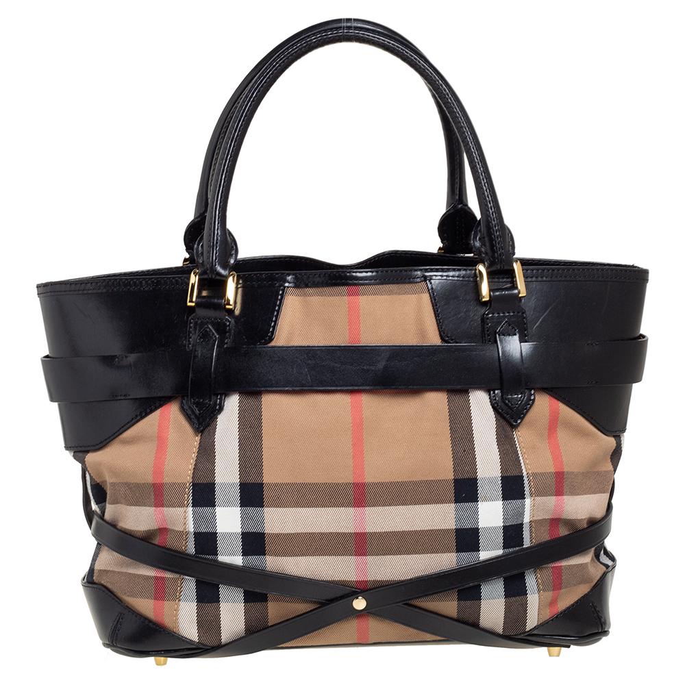This stylish tote from Burberry has been crafted from signature House check canvas and leather into a stylish silhouette. The top opens to fabric-lined compartments spacious enough to hold your everyday essentials. The bag is finished with gold-tone