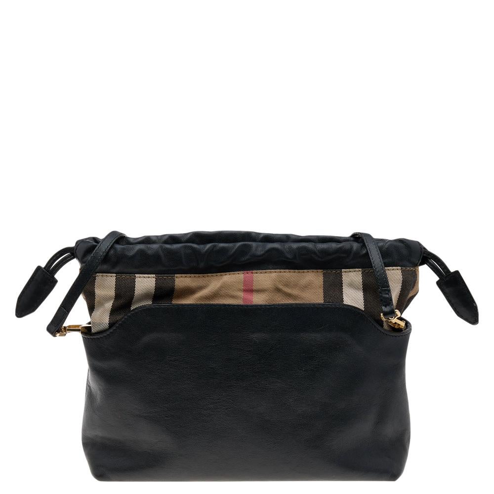 From the house of Burberry, Little Crush is an outstanding fusion of elegance and style. Made in black leather house check canvas, it is styled with signature House check canvas trim and held by a shoulder strap. The drawstring closure secures a