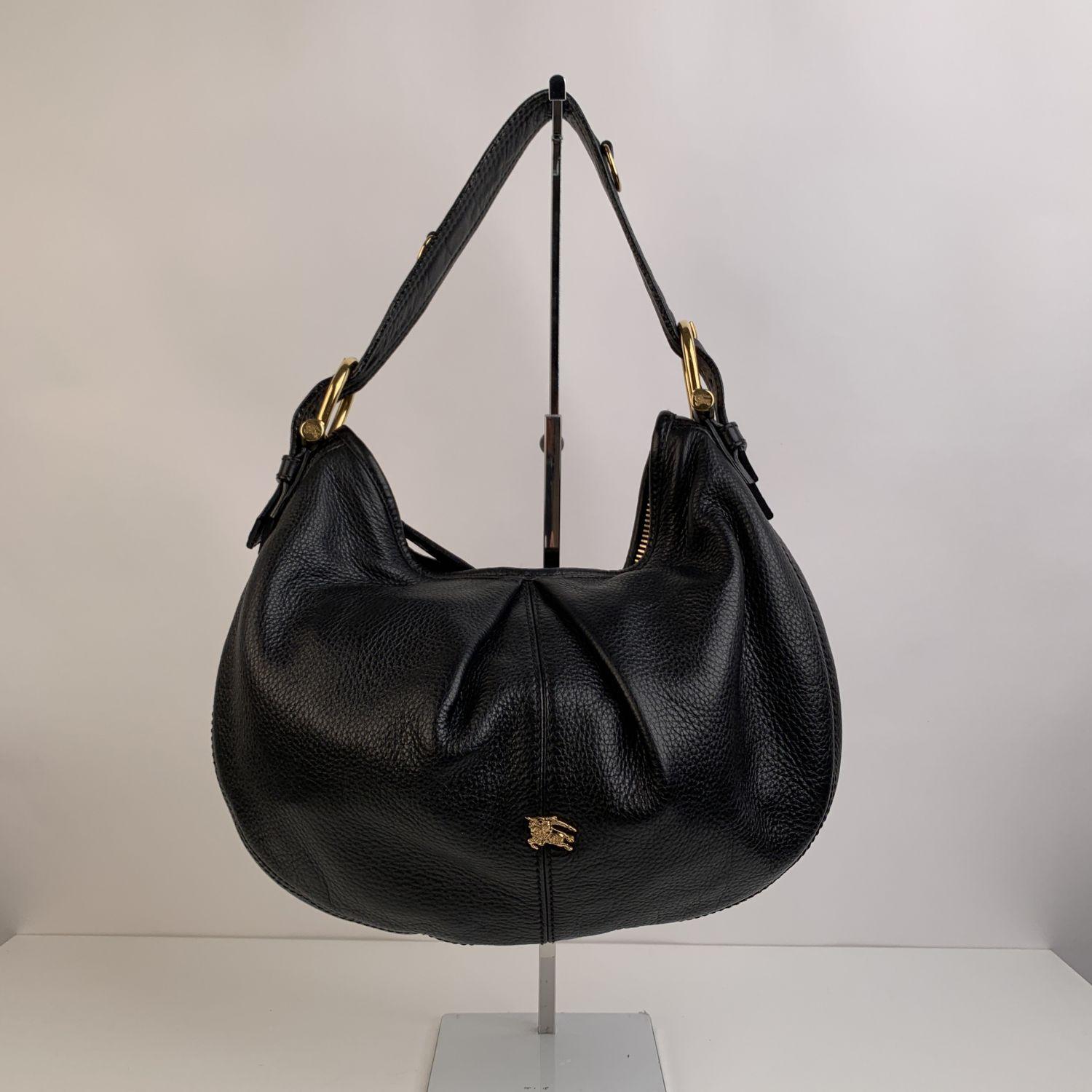 Burberry black leather 'Malika' hobo bag, Gold metal hardware. Upper zipper closure. Nova check fabric lining. 1 side zip pocket and 2 side open pockets inside. 'Burberry' tag inside. Imported







Details

MATERIAL: Leather

COLOR: Black

MODEL: