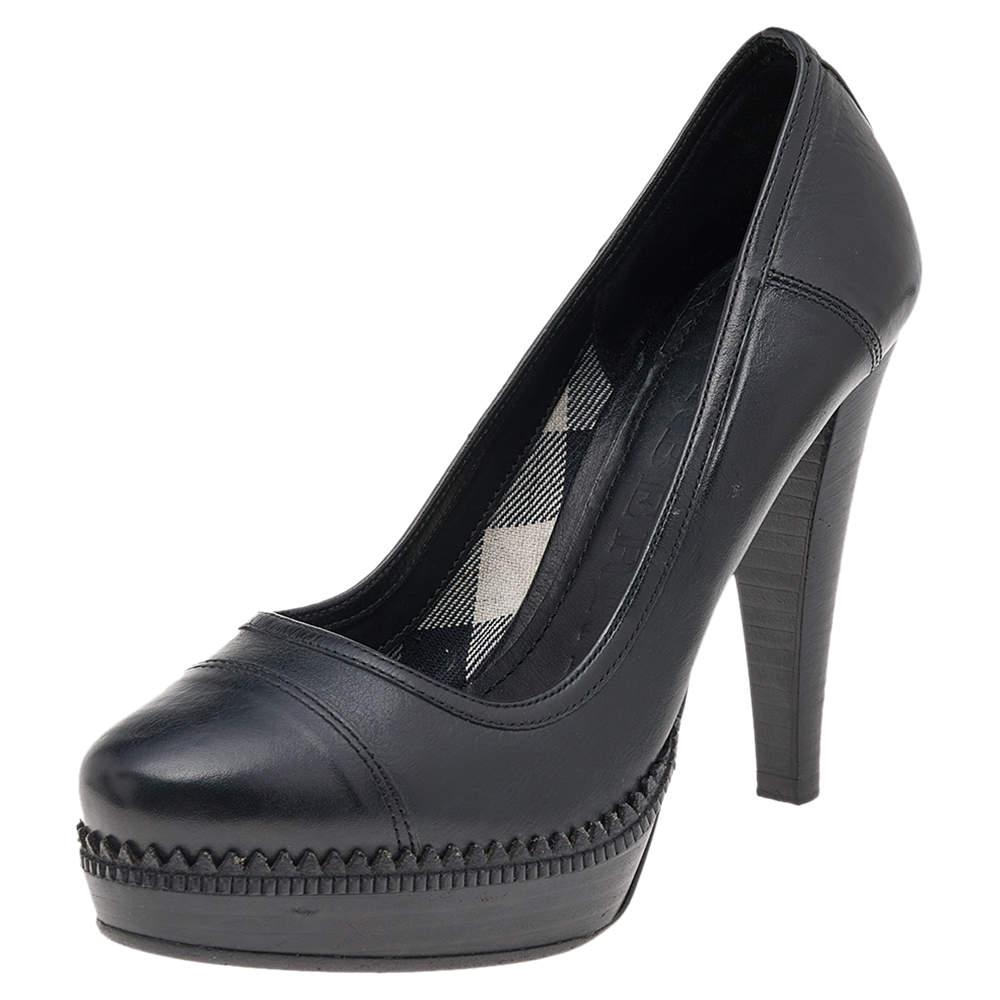 The elegant platform pumps by Burberry are covered in black leather. Covered toes, low platforms, and high heels complete the stunning design.

