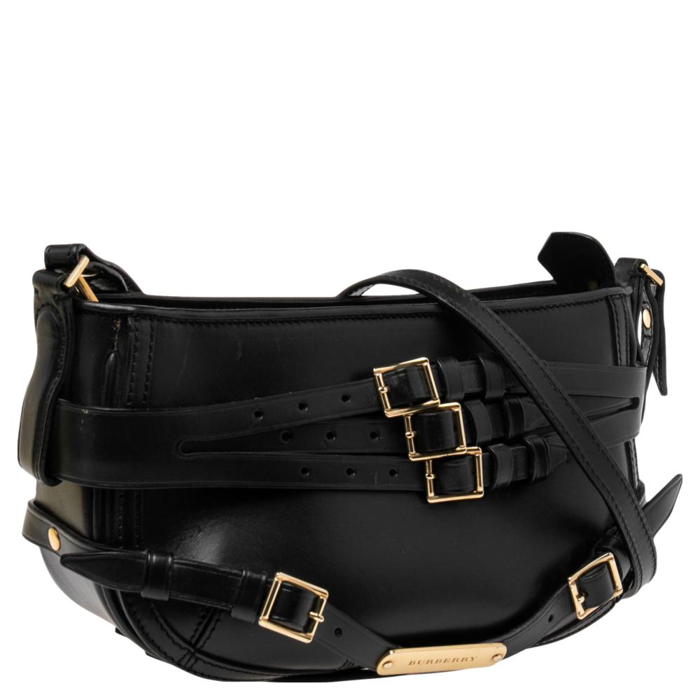 This stylish hobo from Burberry has been crafted from black-hued leather. The zip-top closure opens to a canvas-lined interior that is spacious enough to hold your everyday essentials. The bag comes with a shoulder strap and belt detailing.

