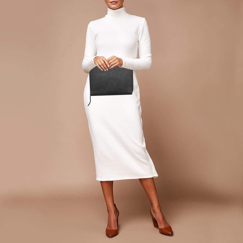 Crafted from high quality black leather it features a sleek finish a secure zip closure and a compact design that exudes sophistication and functionality.