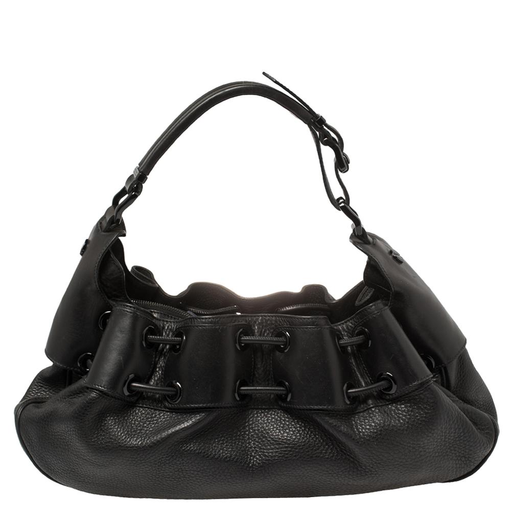 This Burberry Warrior hobo will make a splendid addition to your bag collection. It is crafted from leather and carries a classic shade of black. The hobo bag has a drawstring top and a nylon-lined interior that is secured by a snap button. It is