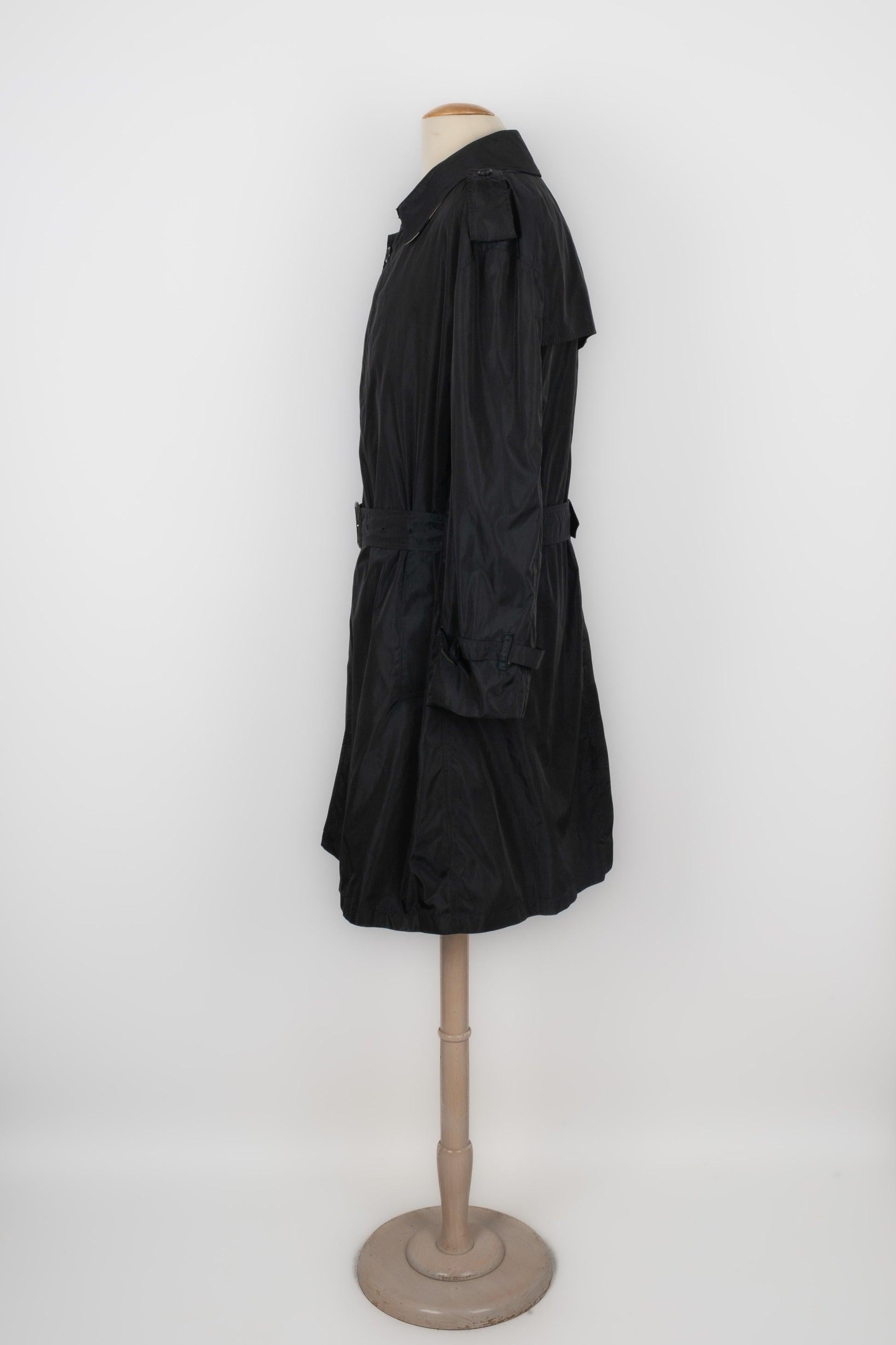 BURBERRY - (Made in England) Black trench coat with a belt. No size indicated, it fits an M size.

Additional information:
Condition: Good condition
Dimensions: Shoulder width: 54 cm - Chest: 60 cm - Sleeve length: 60 cm - Length: 100 cm

Seller